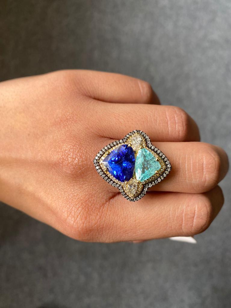 A unique cocktail ring with 5.17 carat natural Tanzanite and 2.66 carat natural Paraiba, with 0.61 carat 2 piece marquise shaped White Diamond and 0.79 carat round  cut White Diamond, all set in solid 18K Gold. The rhodium polish in yellow and