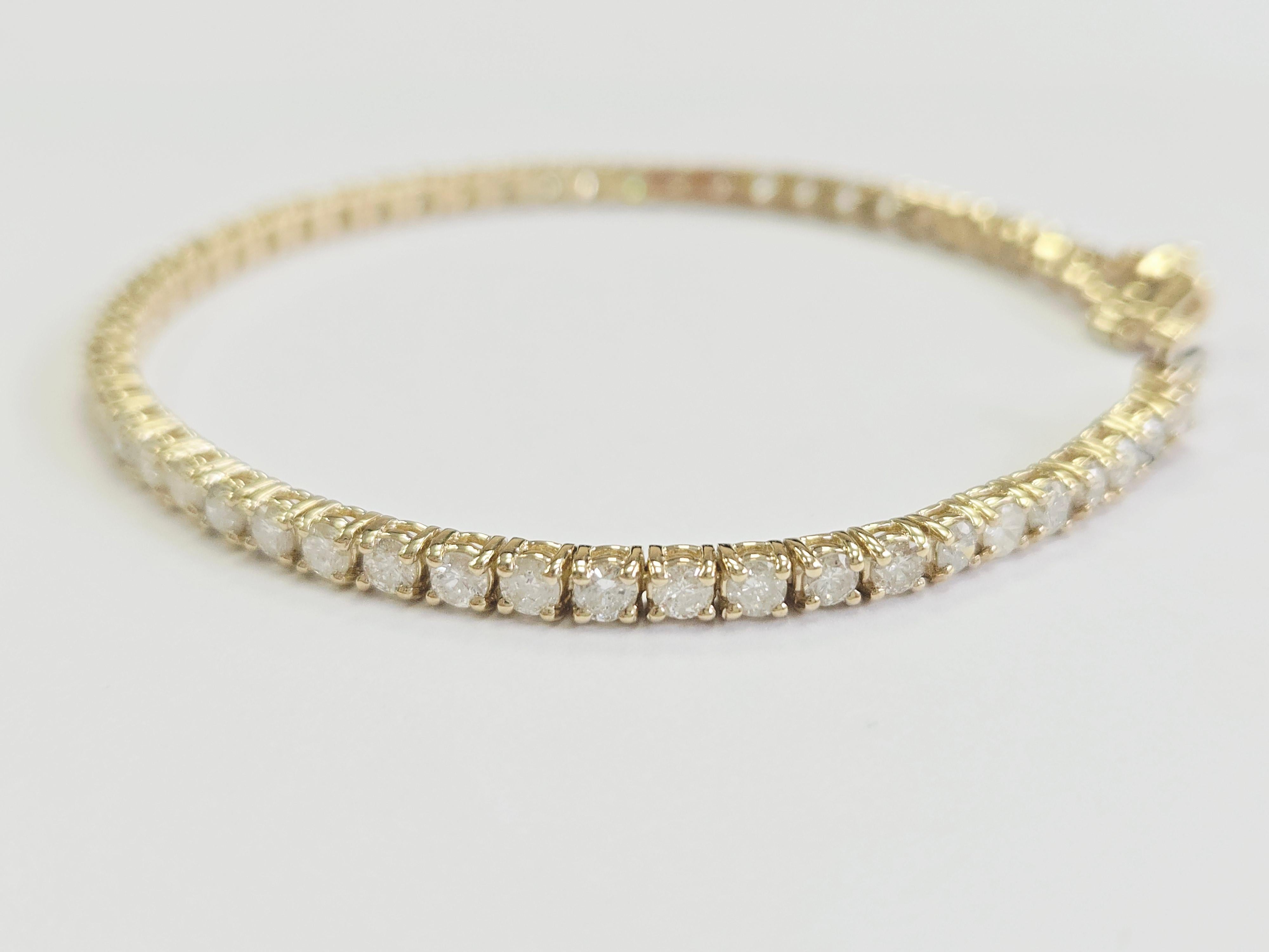 This exquisite tennis bracelet features round brilliant cut white diamonds, known for their exceptional brilliance and sparkle. Set in a classic four-prong style, the diamonds are carefully secured to maximize light reflection for an unmatched