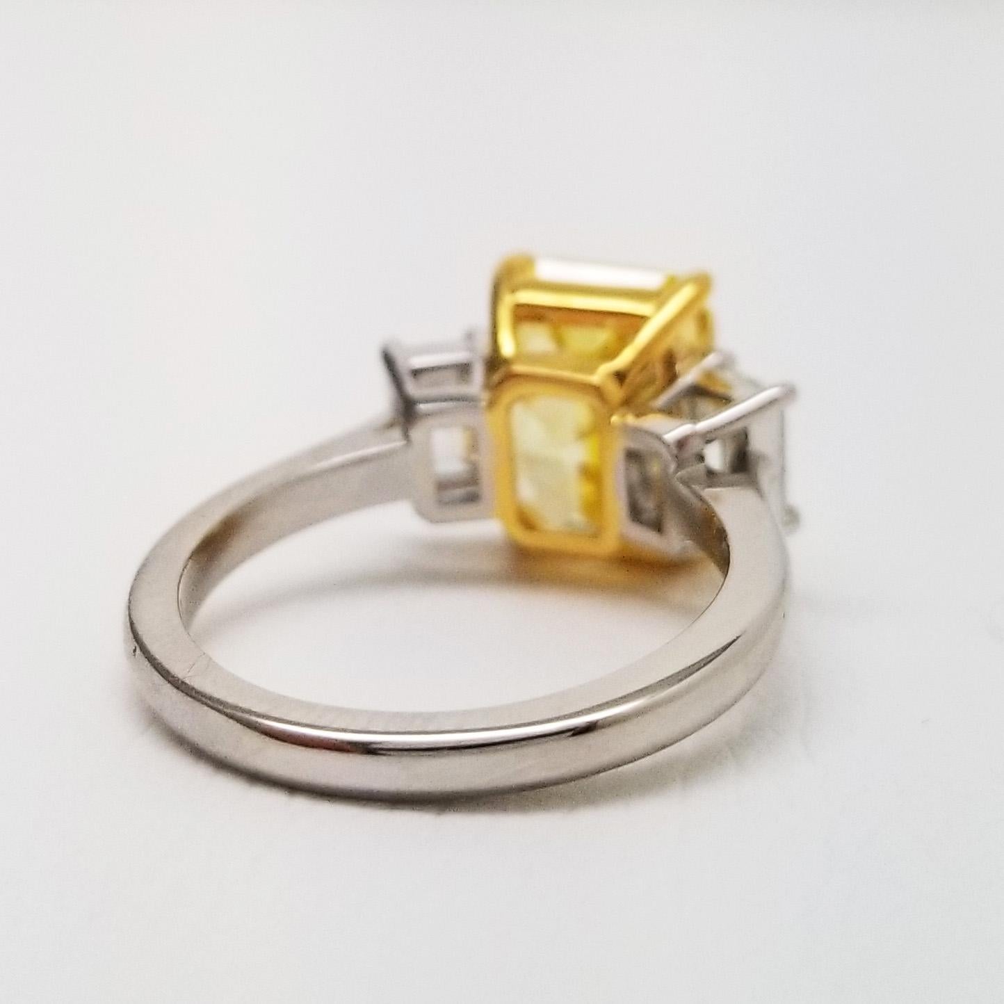 GIA certified VS1 natural fancy vivid yellow natural diamond 5.18 carat engagement ring. Emerald cut 3 Stone engagement ring with fancy vivid yellow diamond GIA 5.18 ct VS1 center stone from Scarselli.

An elegant three-stone engagement ring –