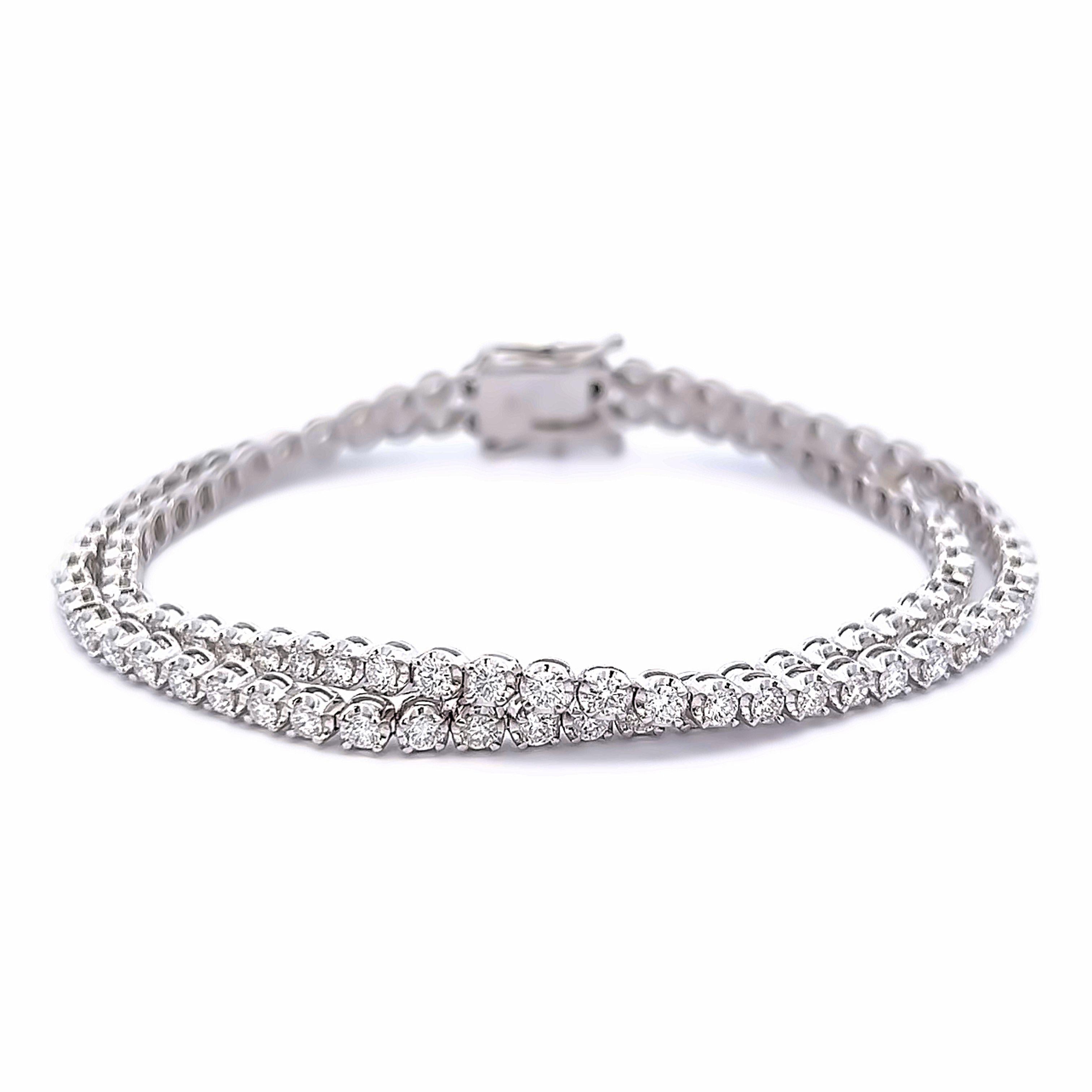 Exquisite and timeless two row diamonds tennis bracelet.
108 diamonds total, 5.18 carats total. Approximately F-G color and VS clarity. Prong set, 16.64 grams, 18k white gold, size 7.
Accommodated with an up-to-date digital appraisal by a GIA G.G.