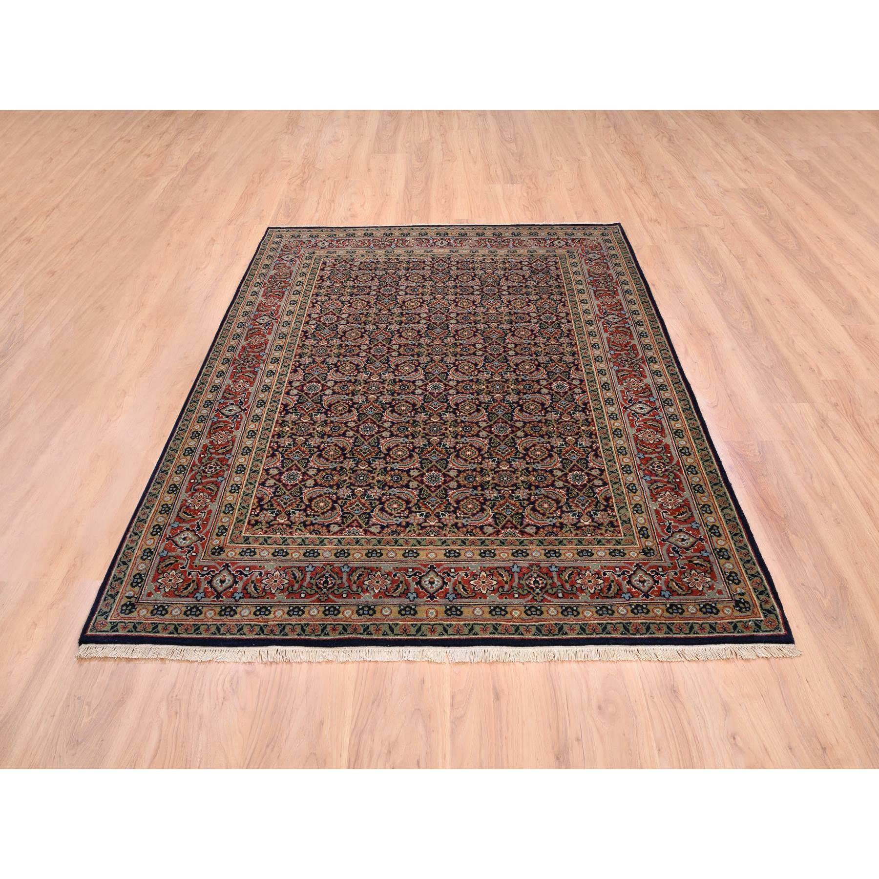 Il s'agit d'un véritable tapis d'Orient en laine nouée à la main et filée à la main, de couleur noir de jais, avec un motif de poisson d'Herat. Il a été noué pendant des mois et des mois selon les techniques séculaires du tissage persan par des
