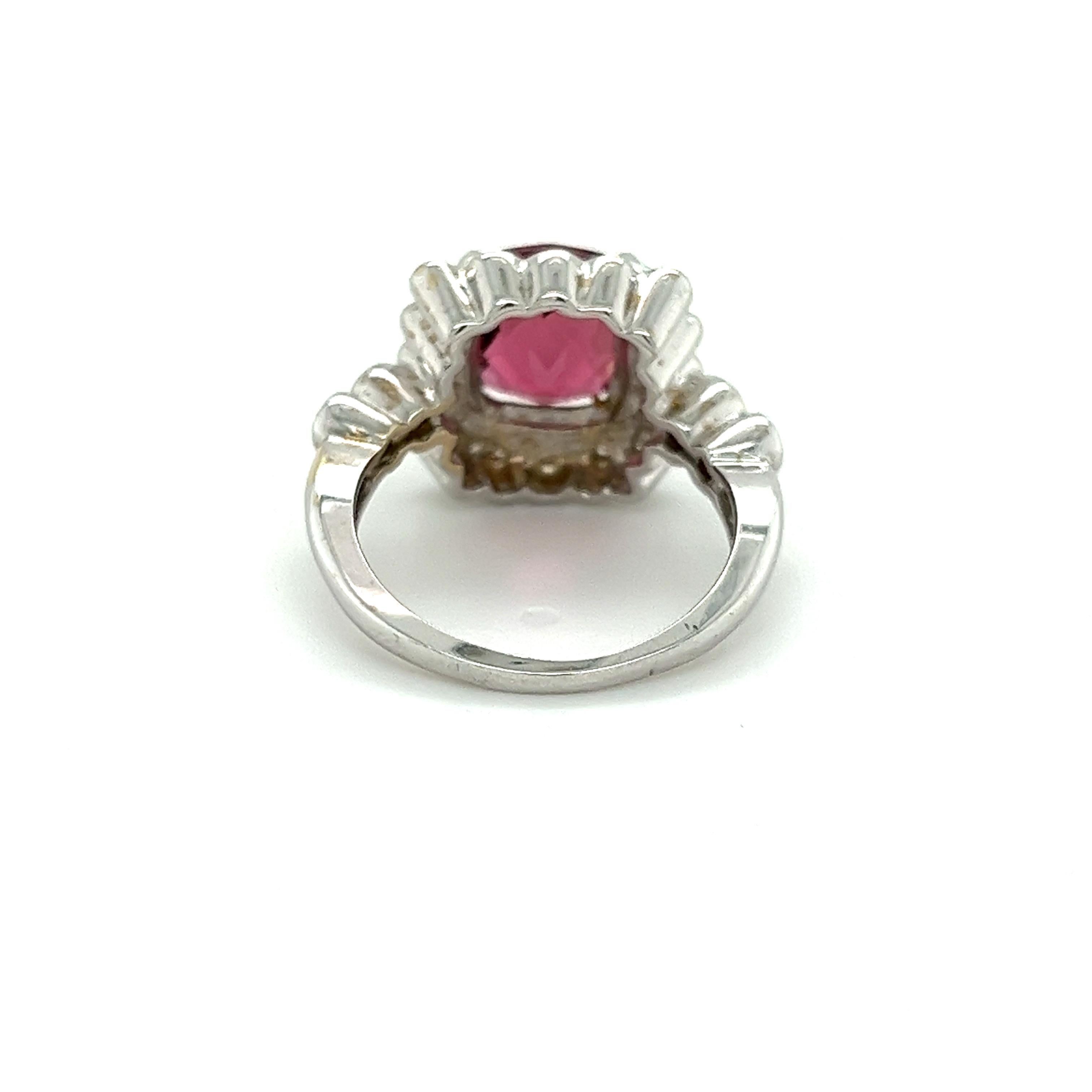 A tourmaline and diamond ring, set in 18k white gold. Centering a checherkbaord cut pinkish purple tourmaline. 4-Prong set and adorned with a round cut white diamond halo and diamond set shank. The tourmaline has a rich, dense mix of pink/purple