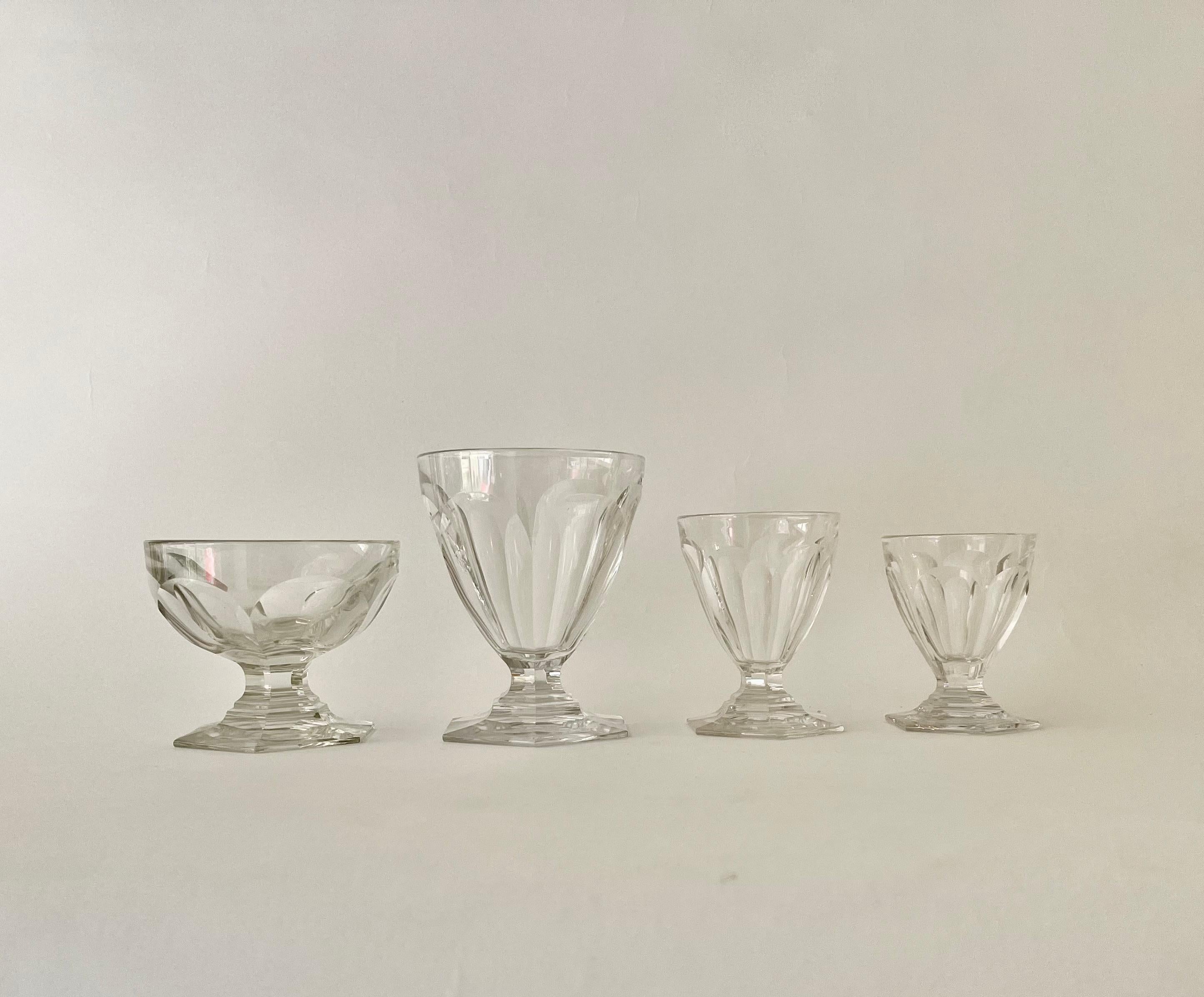 Un très bel et rare ensemble de cristal de Baccarat Bourbon composé de 48 verres et 4 carafes. Les verres et la carafe sont moulés en cristal lourd et comportent des côtés plats largement taillés sur une base hexagonale taillée. Les pièces portent