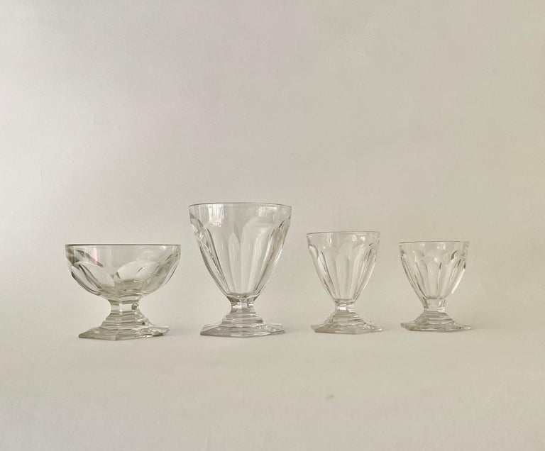 A very beautiful and rare set of Bourbon Baccarat crystal consisting of 48 glasses and 4 decanters. The glasses and decanter are moulded of heavy crystal incorporating wide cut flat sides on a hexagonal base cut in. The pieces all bear the Baccarat