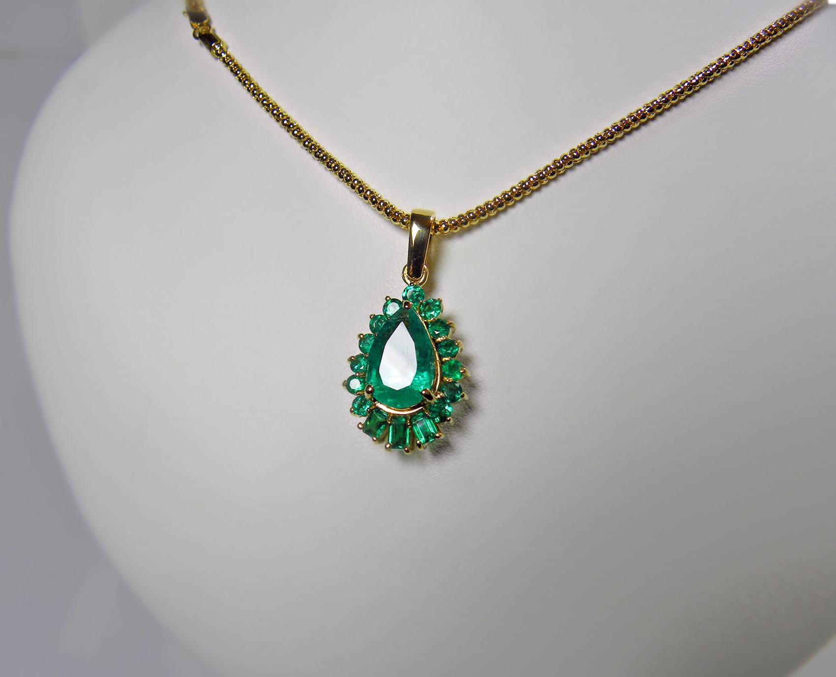 This is a 5.20-carat vibrant AAA green natural Colombian emerald drop pendant necklace crafted in 18K yellow gold. The center emerald is a pear cut weighing over 4.0 carats and is surrounded by 1.20 carats of emeralds. The pendant measurements are