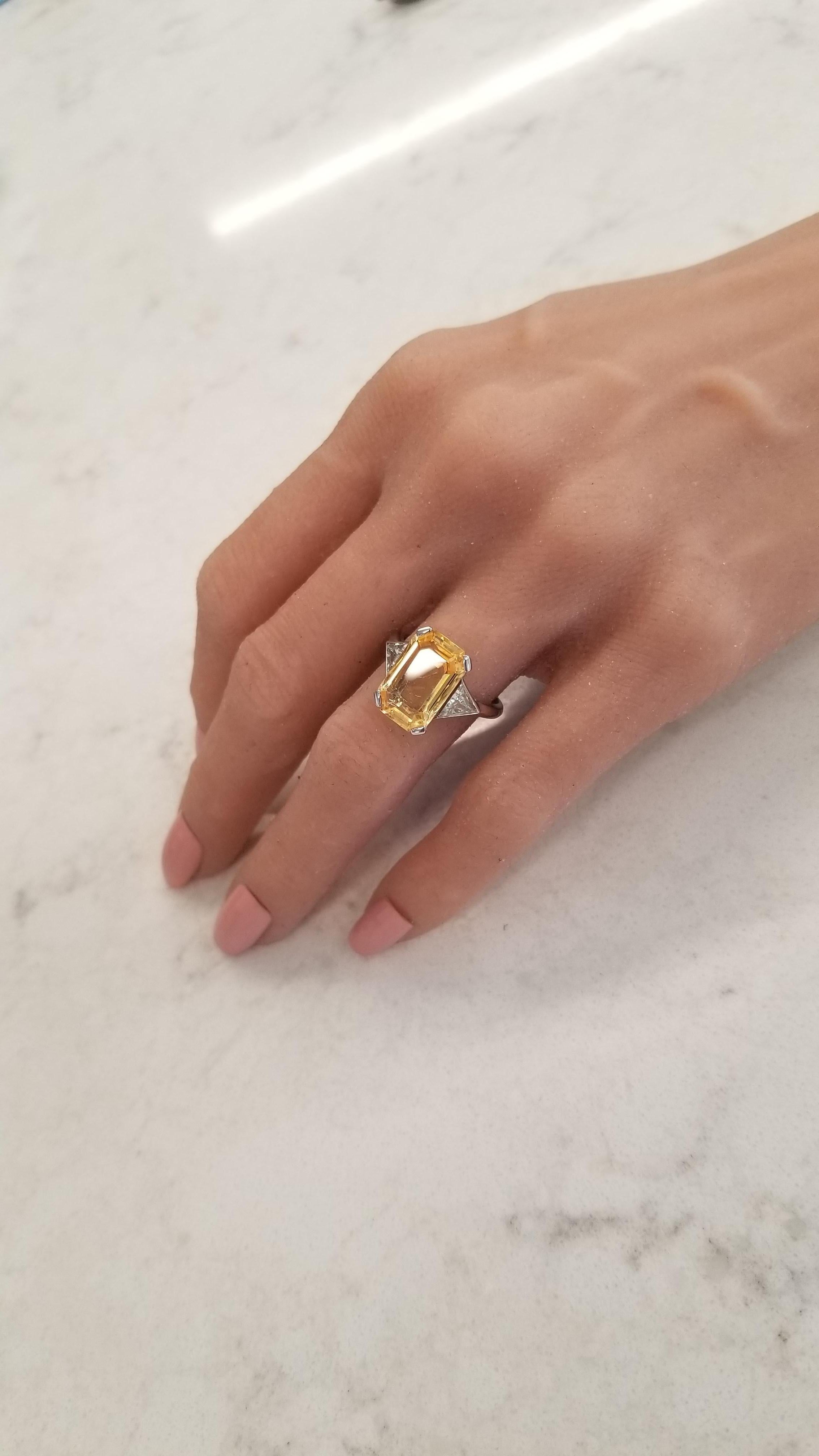 This is the classic 3-stone luxury ring. Featured is a 5.20 carat, prong set, emerald cut yellow sapphire with measurements of 14.50x9.20MM. This yellow sapphire is unheated making it extremely scarce. Its origin is Sri Lanka; its color is intense