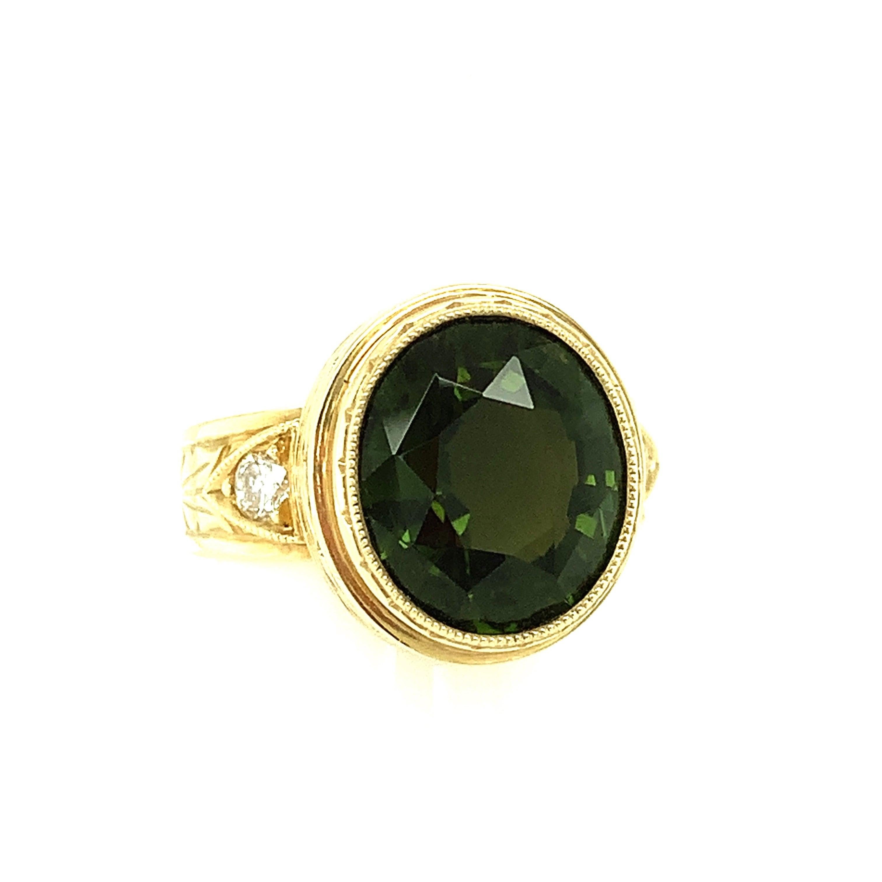 This handmade 18k yellow gold ring features a beautifully crystalline, 5.20 carat oval tourmaline with gorgeous, rich green color! The ring was designed to showcase this brilliant gem, whose body color can be described as deep green with hints of
