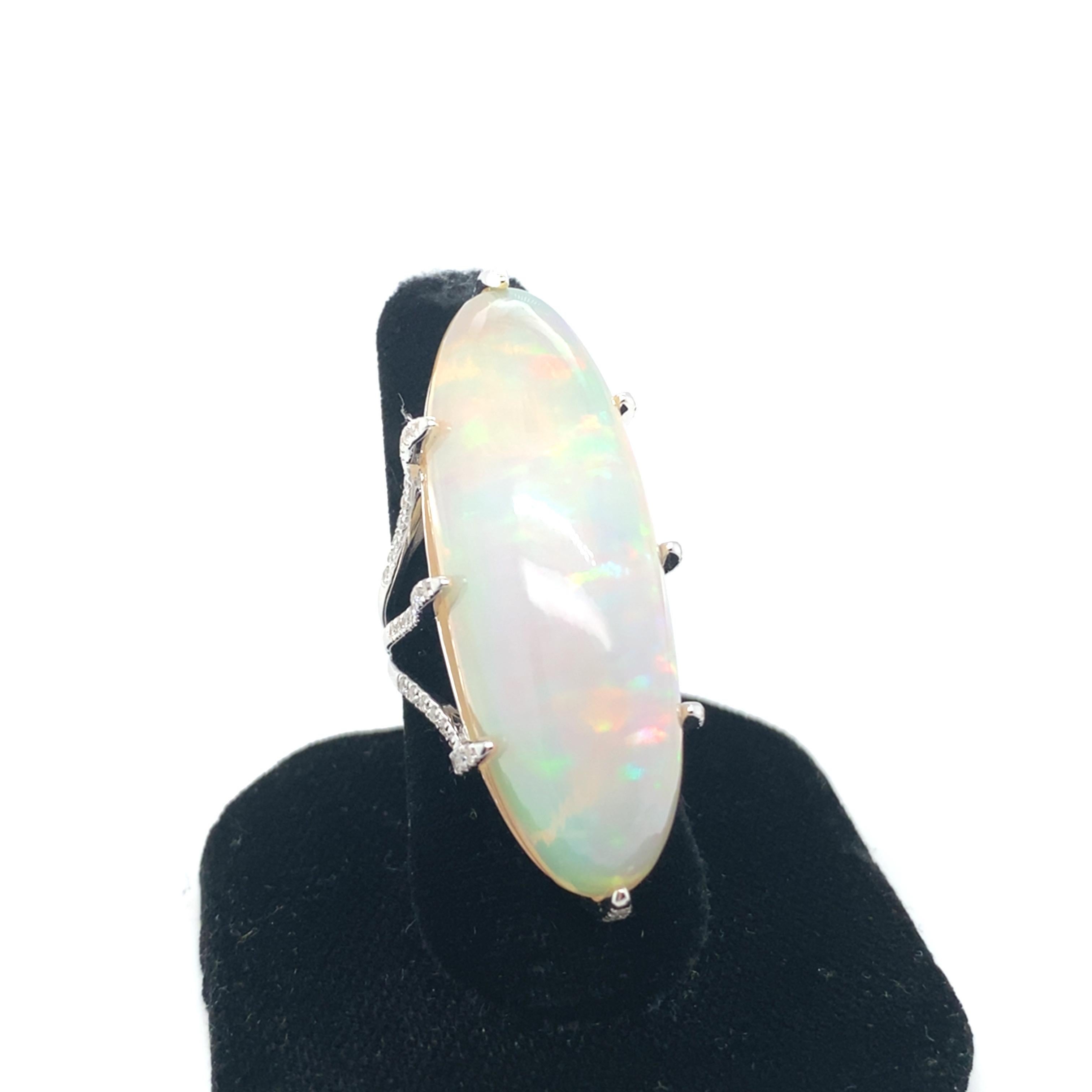 This breathtaking 52.05-carat marquise-cut opal cocktail ring is accented with pave diamonds on the claws and band, adding a touch of sparkle to the exquisite design. The opal is hand-cut and polished to perfection, showcasing its stunning