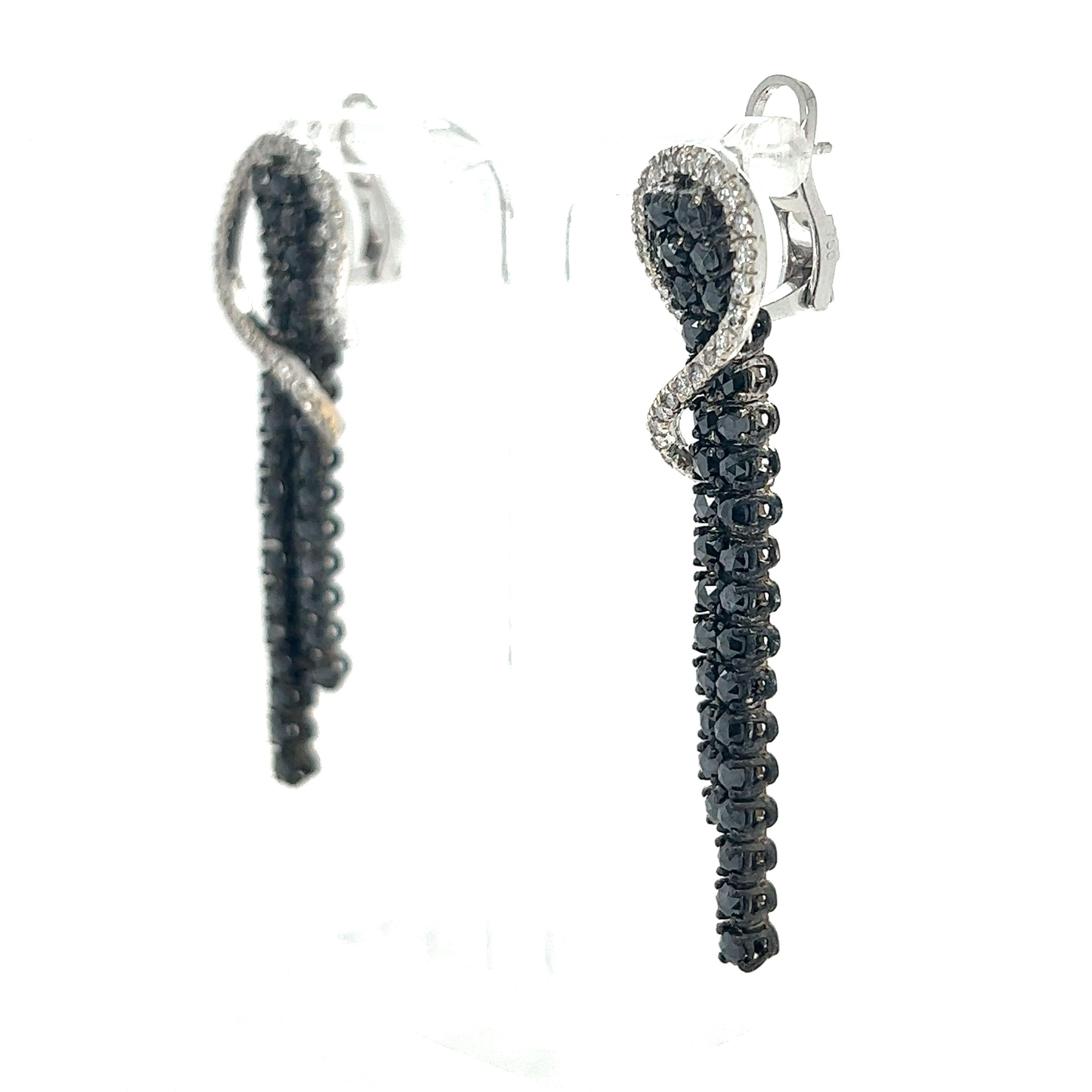 These gorgeous earrings have Natural Black Rose Cut Diamonds that weigh 4.42 Carats and Natural White Round Cut Diamonds that weigh 0.79 Carats. The total carat weight of the earrings are 5.21 Carats.  The clarity and color of the white diamonds are