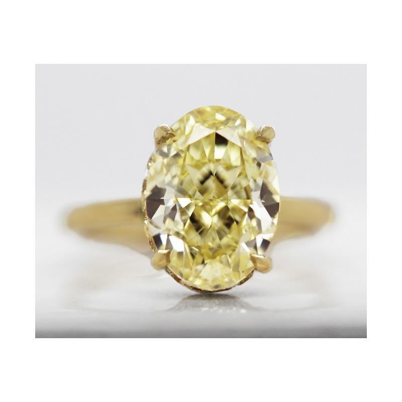 5.22 carat Fancy Intense Yellow natural, GIA certified oval-cut diamond engagement ring on a yellow gold band. Natural fancy color diamond engagement ring with 5 plus carat intense yellow brilliant oval diamond with VVS2 clarity on an 18k gold