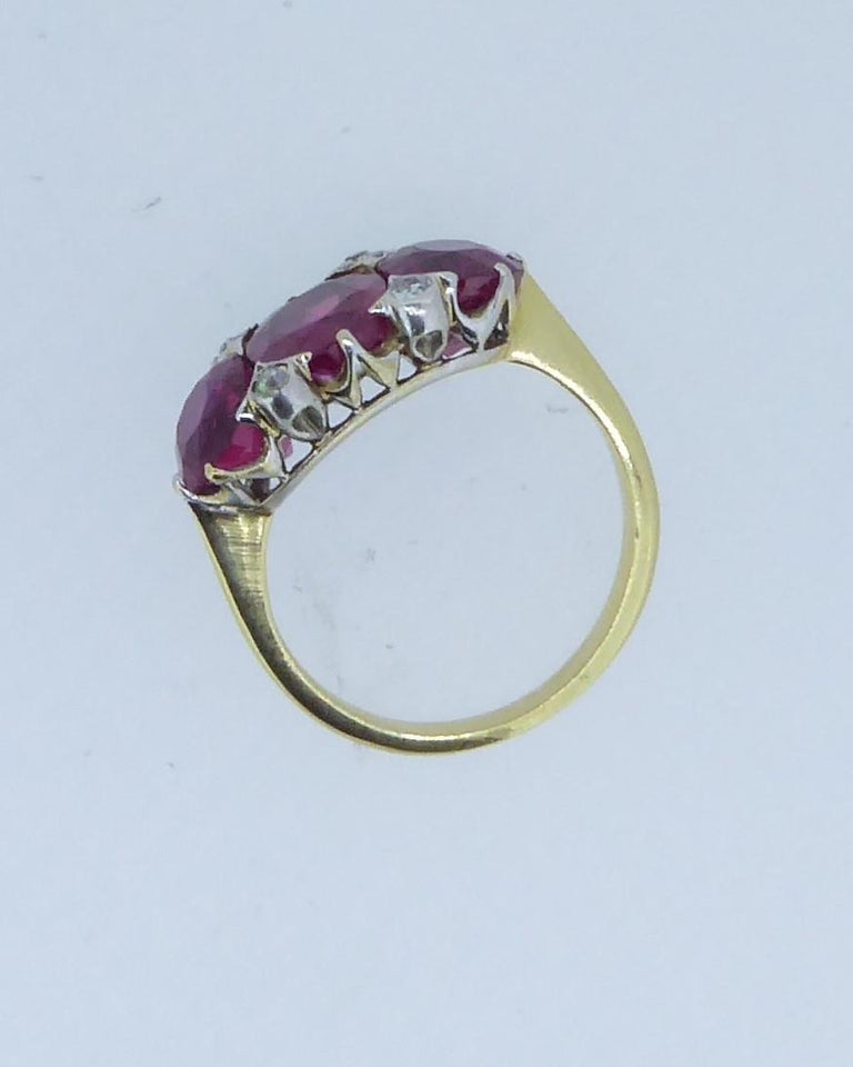 A 5.22 Carat Unheated Burmese Ruby 3-Stone and Diamond Platinum and Gold Ring. Circa 1910. The three claw-set rubies of approx 1.83cts, 1.70cts and 1.69cts with small rub-over diamond accents. Set in platinum and yellow gold. The rubies of slight