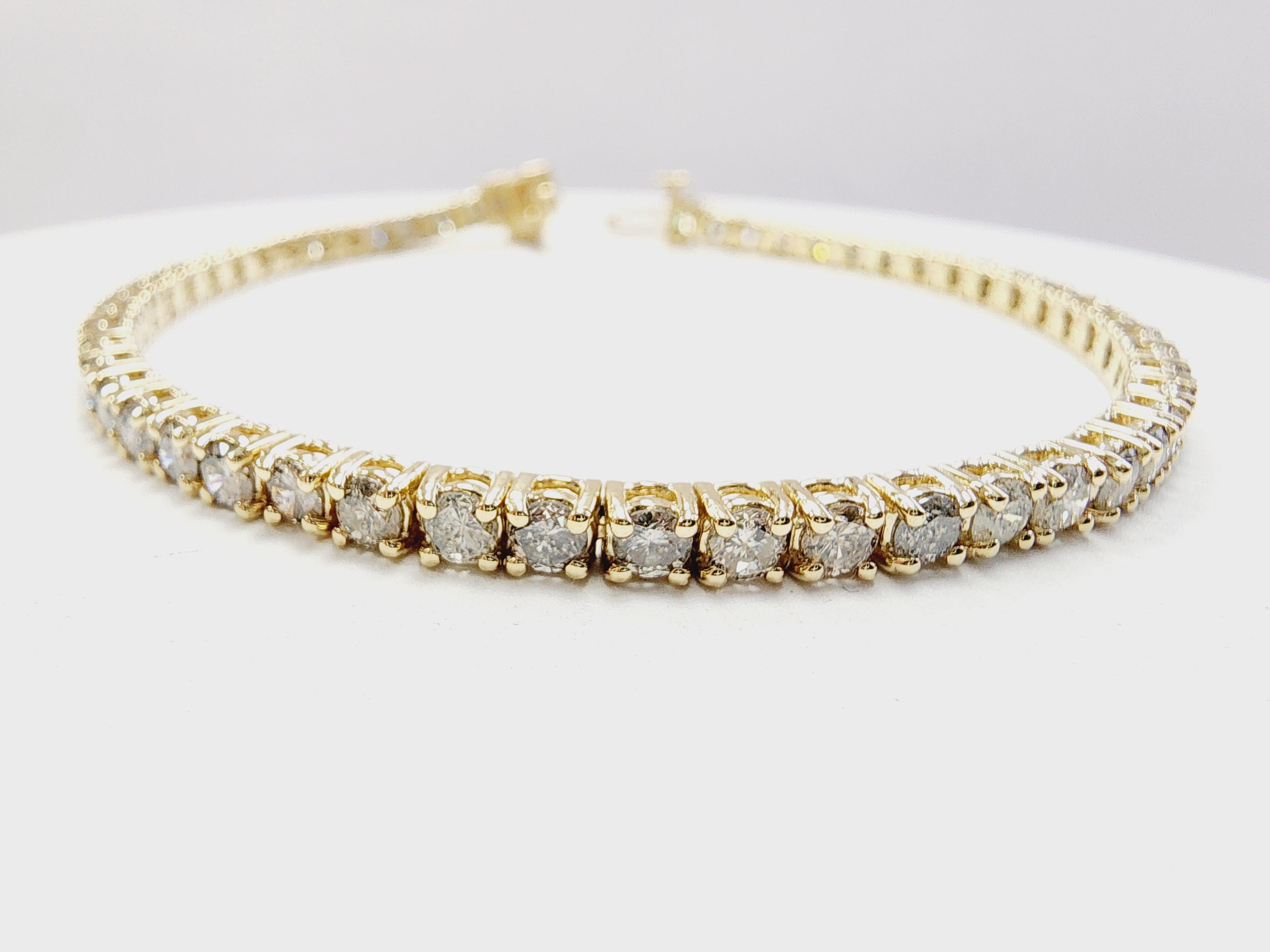 Beautiful quality tennis bracelet, round-brilliant cut white diamonds, and excellent shine. 
14 karat yellow gold classic four-prong style for maximum light brilliance. 

Length: 7 inch 
Color Range: G
Clarity Range: I2
Width: 3.1 mm
Weight: 10.60