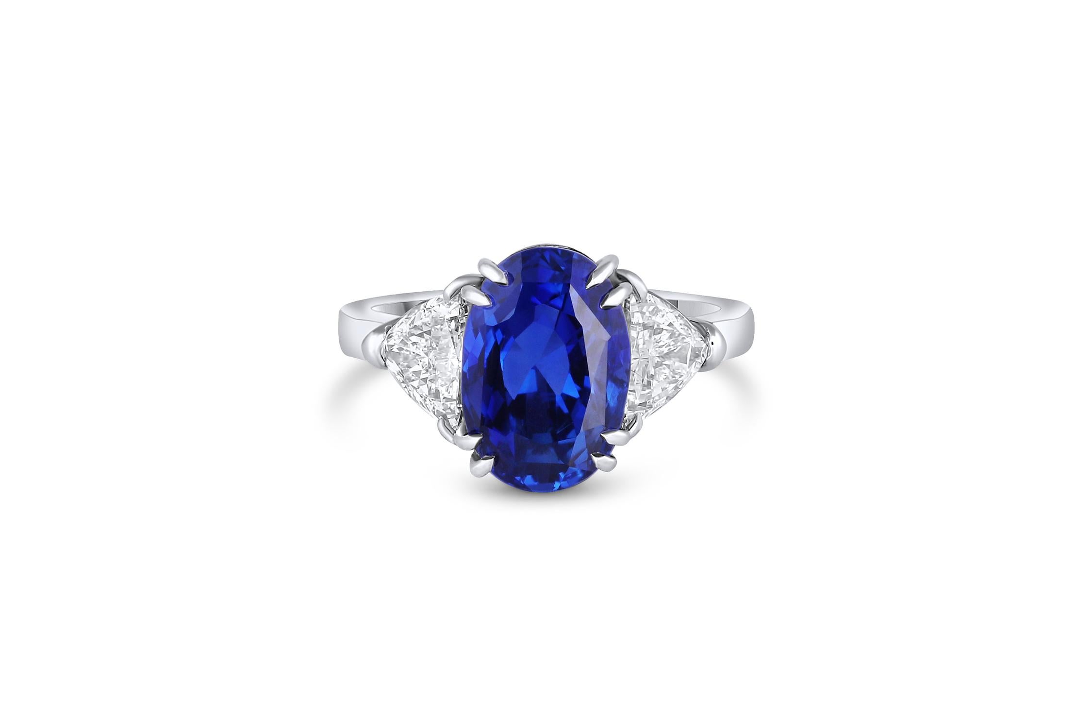 This extraordinary ring is crafted of platinum with a 5.23 carat natural unheated Madagascar sapphire. Features include two trillion cut diamonds weighing a carat total weight of 1.12 carats.