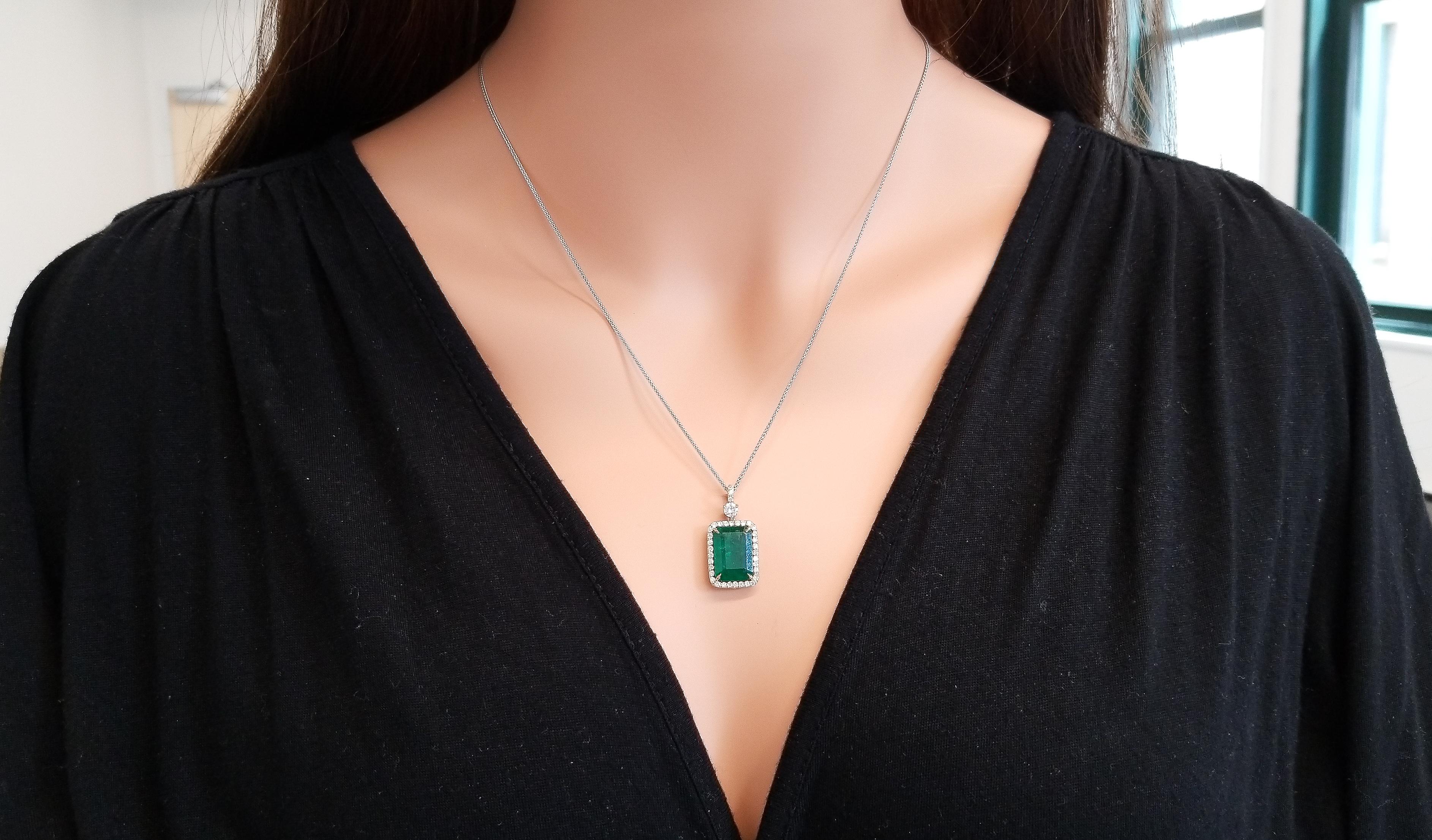 This is a 5.23 carat radiant cut emerald that takes the spotlight on this elegant dangle pendant in a prong setting with measurements of 13.5mm x 9.5mm. The gem origin is Zambia. The transparency and color is what you want. The luscious green of the