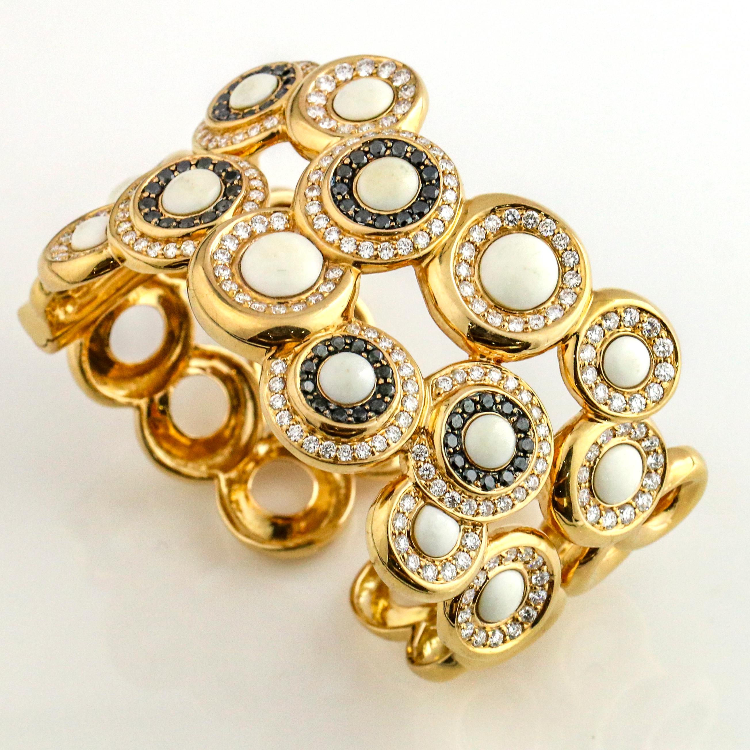 Wide fashion bangle bracelet in 18 karat yellow gold with white coral stones surrounded by black and white round-cut diamonds. Made in Italy. Signed * 1608 MI.