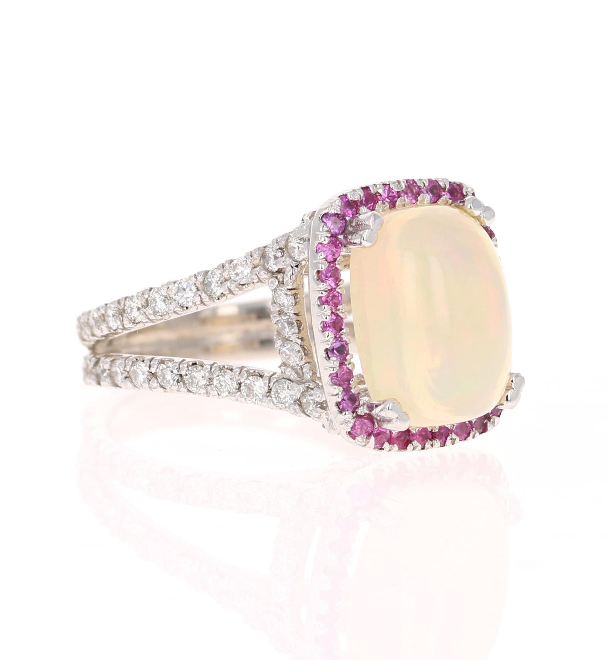 This stunning piece has a 3.80 carat opulent Opal set in the center of the ring.  The Opal is surrounded by a row of 28 Pink Sapphires that weigh 0.40 carats and 72 Round Cut Diamonds that weigh 1.05 carats.   The total carat weight of the ring is