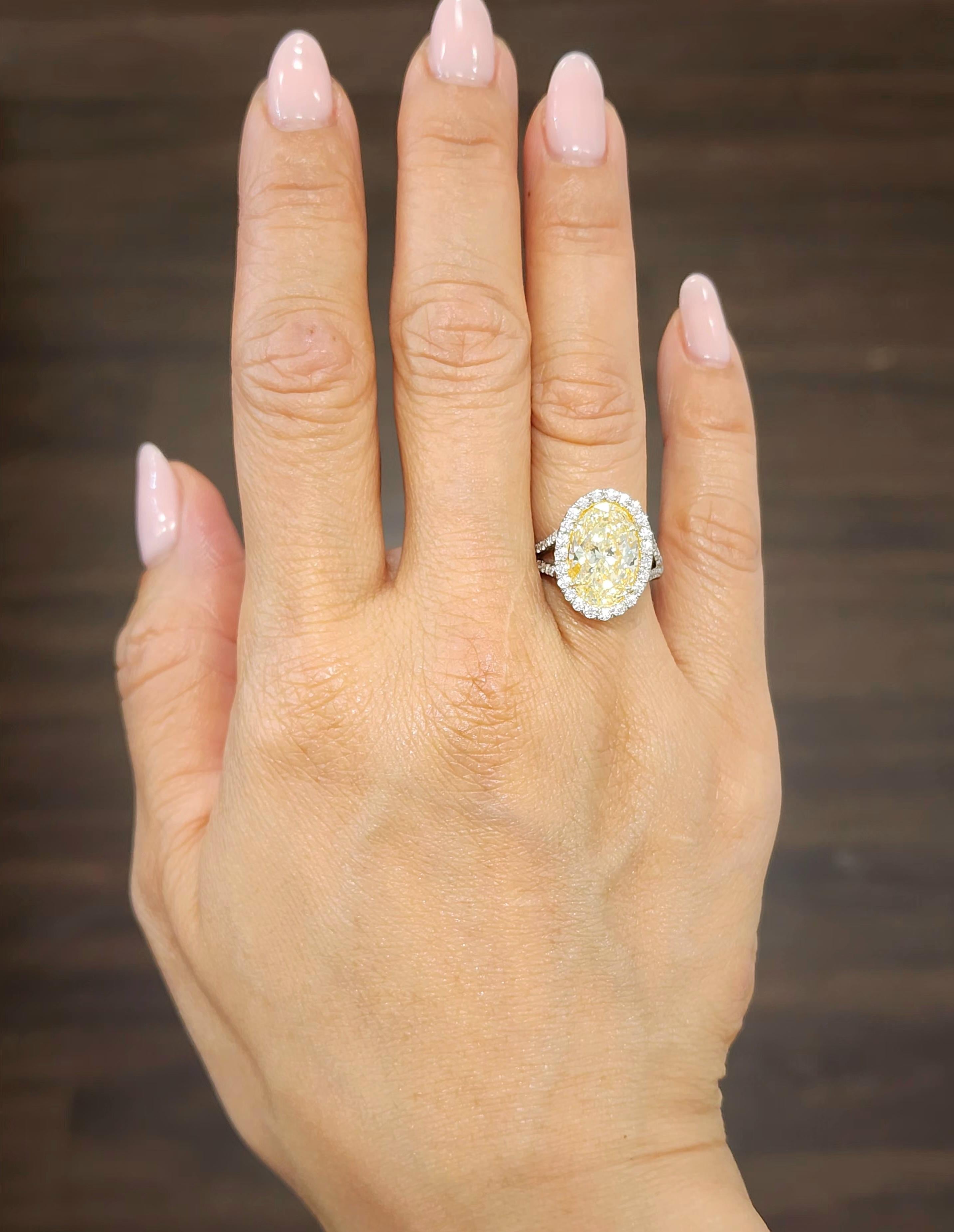 This showstopper of a piece is breathtaking. The ring features a 4.57 ct natural yellow center stone with 0.68 ct diamonds surrounding the stone in a halo setting. The diamonds boast a color of E/F and VS1 in clarity. Such a magnificent piece to