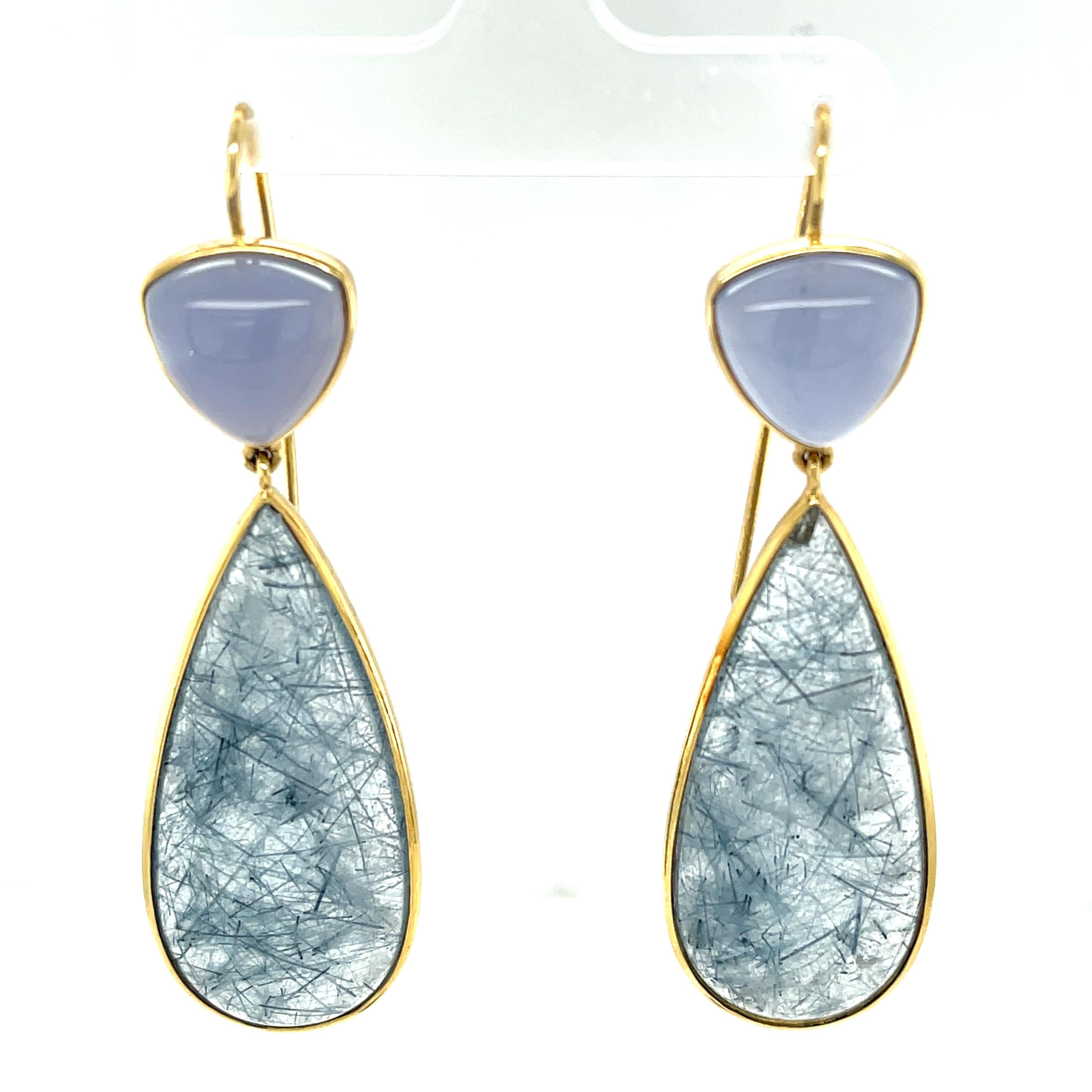 These bezel set actinolite and chalcedony cabochon drop earrings are a unique blend of color, texture and form! Translucent lavender chalcedony triangles sit atop transparent quartz pendalogues with beautiful blue actinolite needle inclusions in