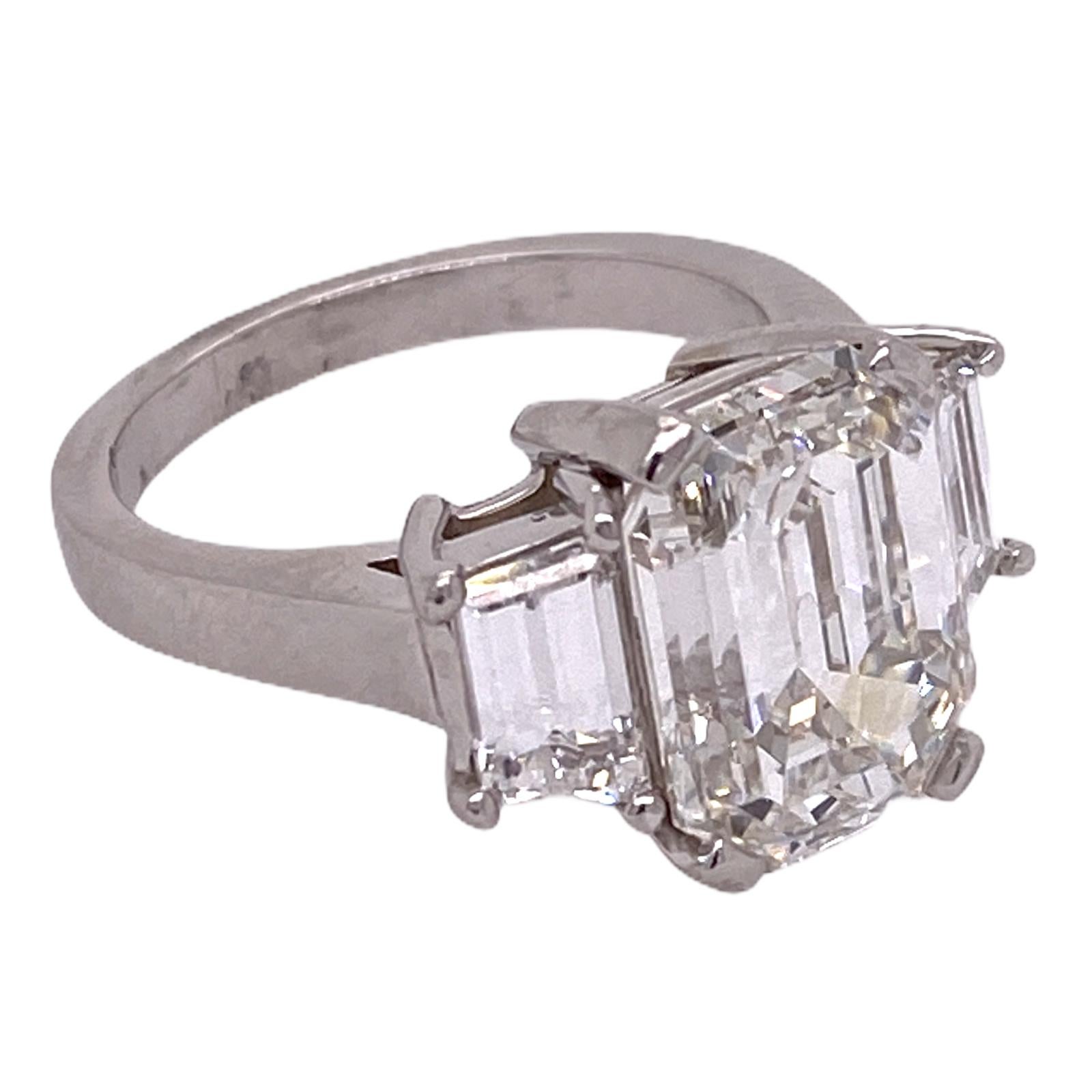 Stunning emerald cut diamond engagement ring handmade in platinum. The emerald cut diamond weighs 5.28 carats and is graded H color and VS2 clarity by the GIA. The two side trapazoid cut diamonds weigh 1.00 carat total weight. The platinum mounting