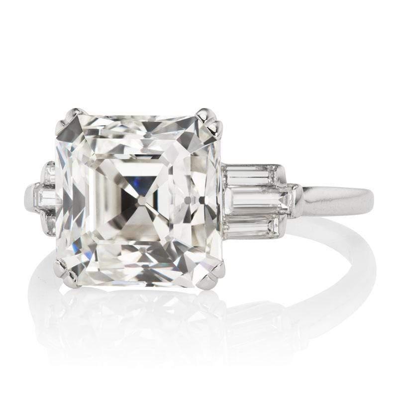 This ring is an authentic vintage diamond ring from the Art Deco Era. The ring centers a GIA-certified 5.29-carat Asscher cut diamond of J color, VS1 clarity. The stone is set in a 4-prong platinum setting with three horizontally baguettes to either
