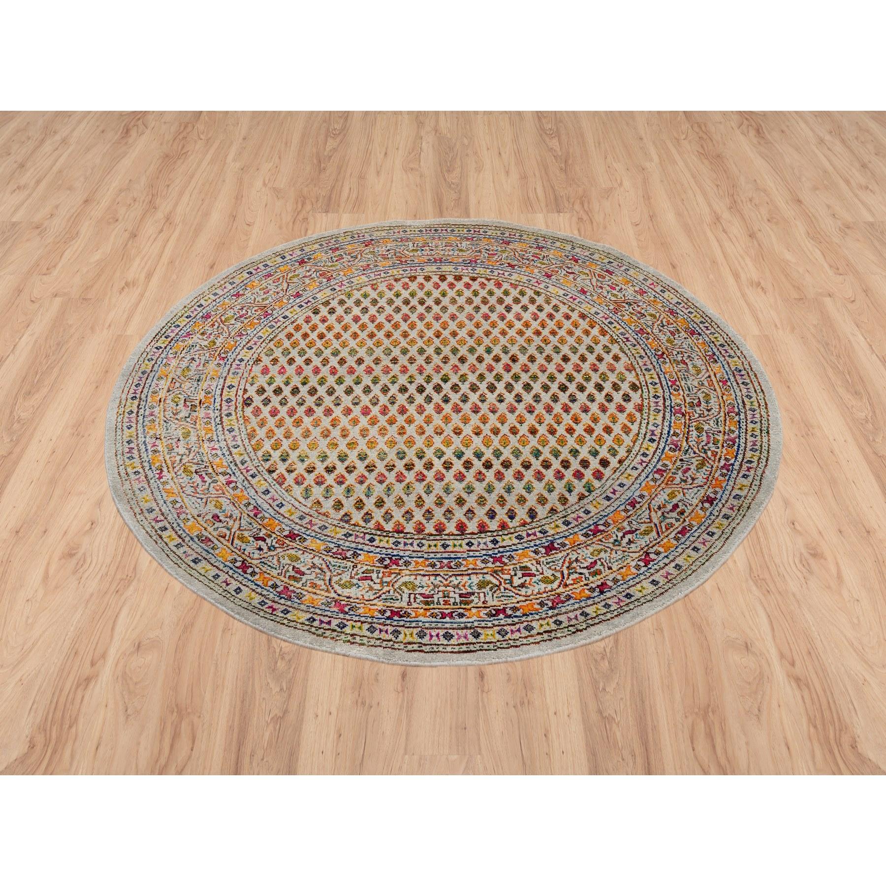 Si tratta di un autentico tappeto rotondo orientale in lana e seta sari annodato a mano di colore beige ispirato al Sarouk Mir con disegno Boteh ripetitivo. È stato annodato per mesi e mesi secondo le secolari tecniche artigianali di tessitura da