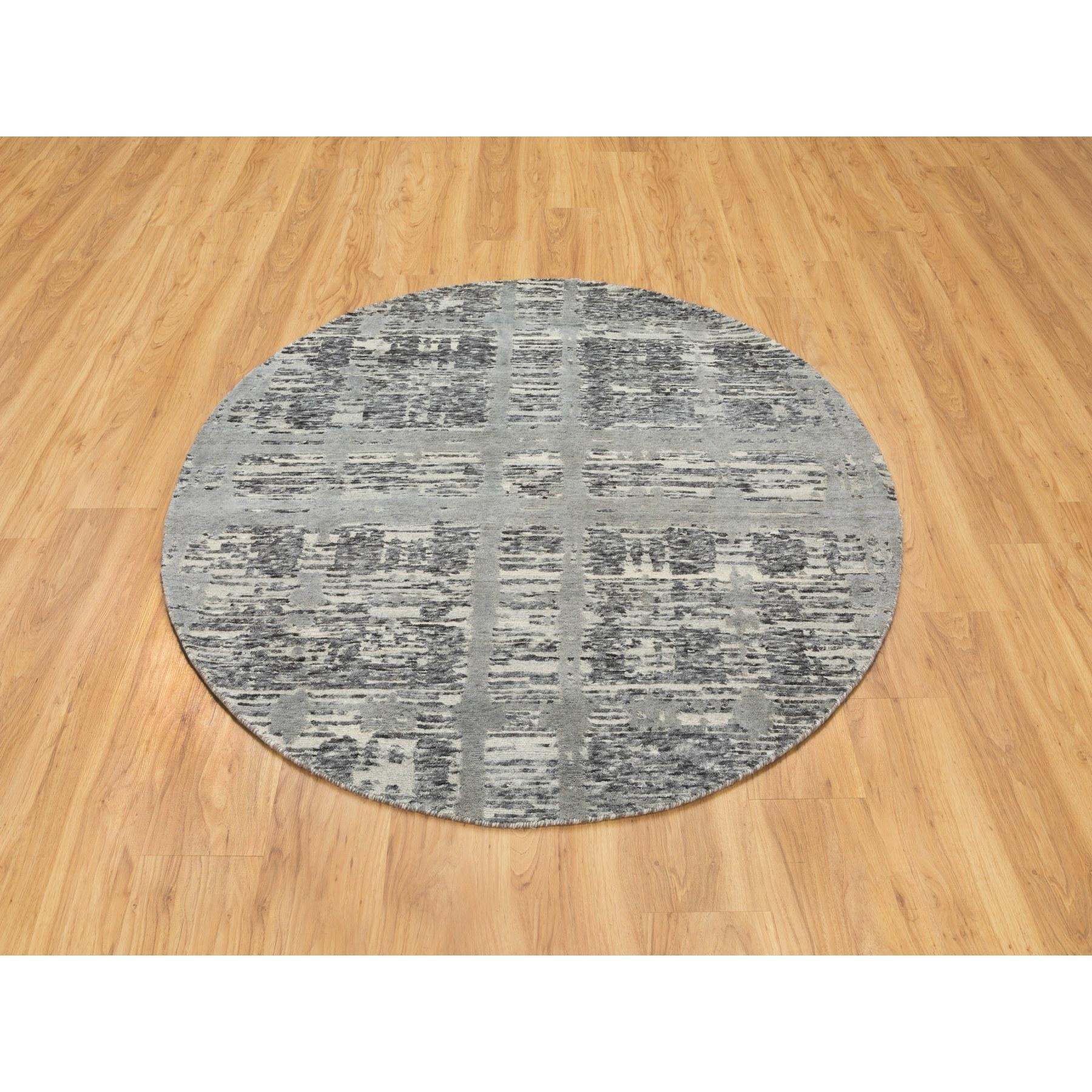 Se trata de una auténtica alfombra oriental redonda anudada a mano con un diseño moderno de cruces entrecruzadas, hilada a mano y sin teñir, de lana natural gris sin teñir. Ha sido tejida durante meses y meses con las centenarias técnicas
