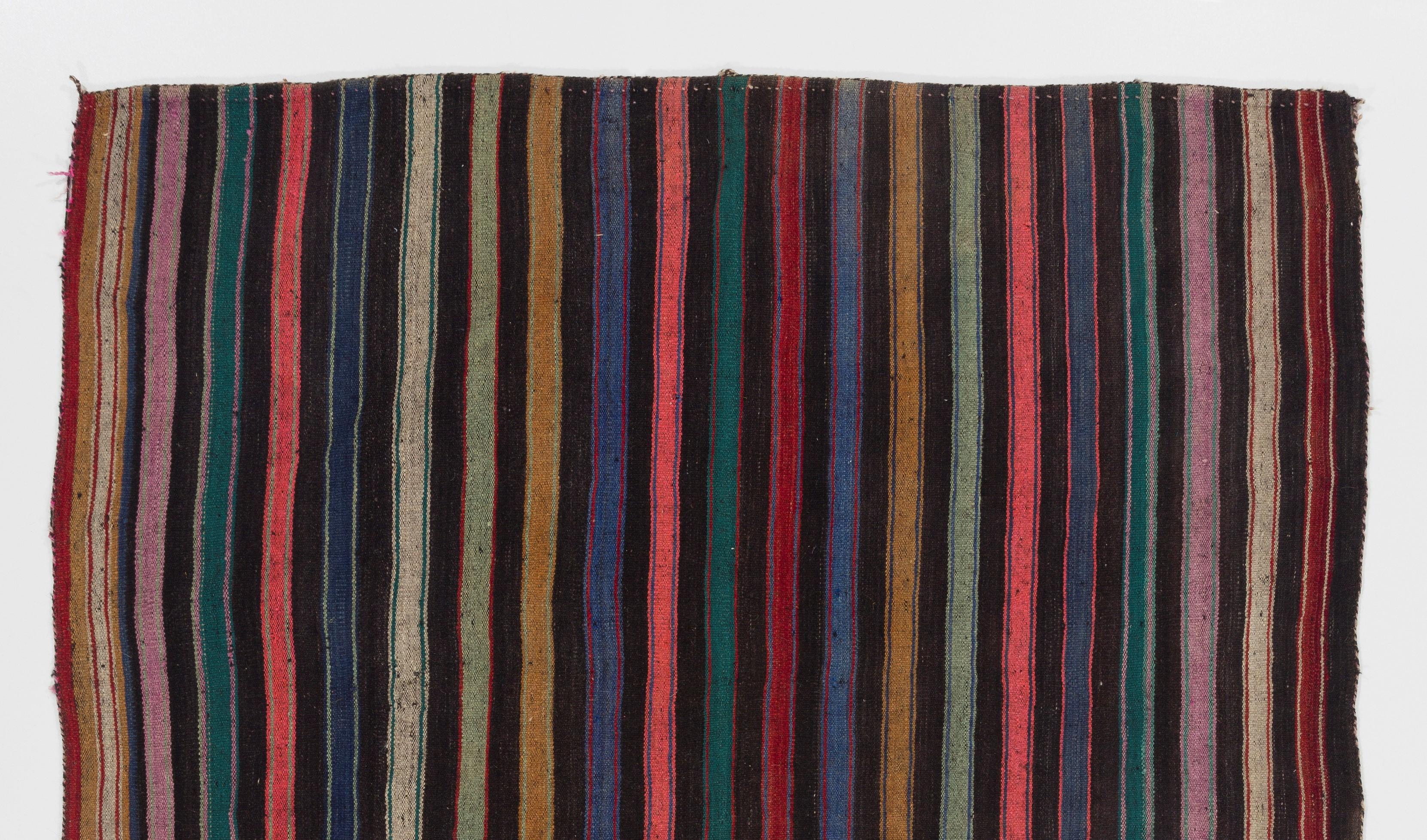 A simple wool rug with a minimalist aesthetic handwoven by the Nomadic tribes in South Central Turkey in the 1960s featuring a design of colorful stripes. Made entirely of wool, in very good condition, sturdy and professionally cleaned.

Size: