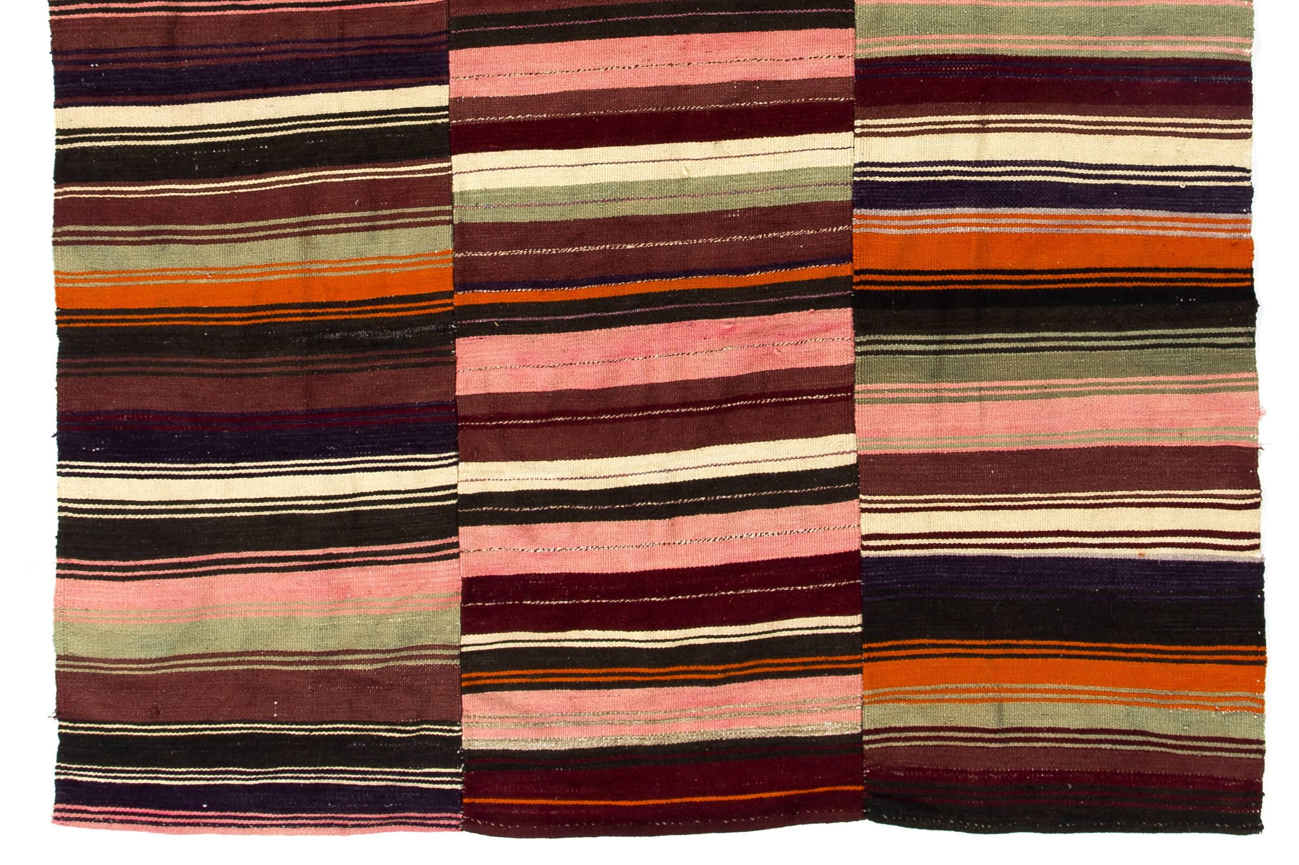 This elegant and colorful vintage kilim rug was handwoven in three panels. It is made of cotton and wool, blended nicely to create a fine sturdy floor covering. It features a simple, minimalist striped design with a gorgeous color palette of cotton