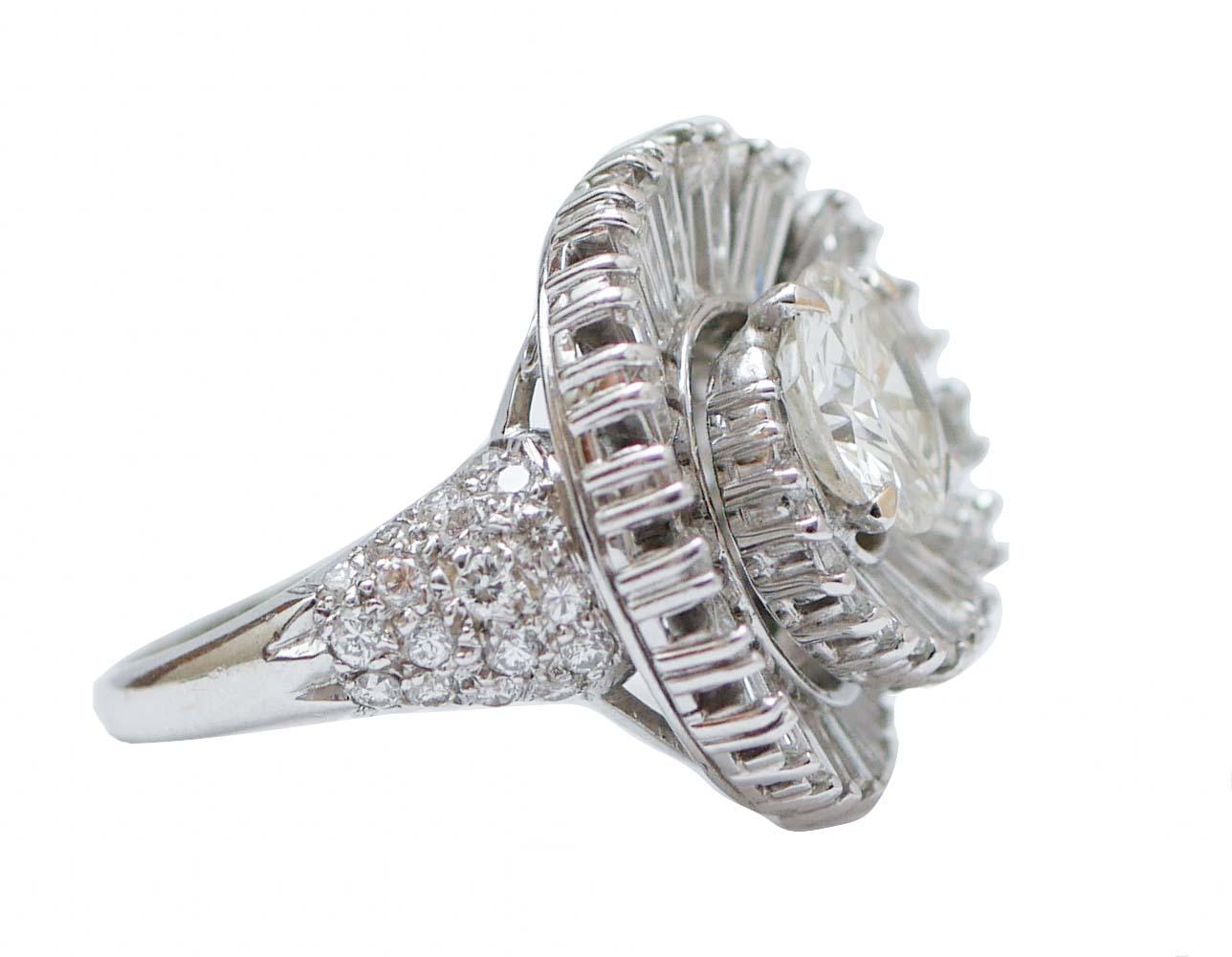 Elegante anillo de estructura de platino montado con un diamante central de 2,15 ct rodeado de un abanico plegable de diamantes talla baguette. En el tallo, diamantes talla brillante.
Este anillo fue totalmente hecho a mano por maestros orfebres