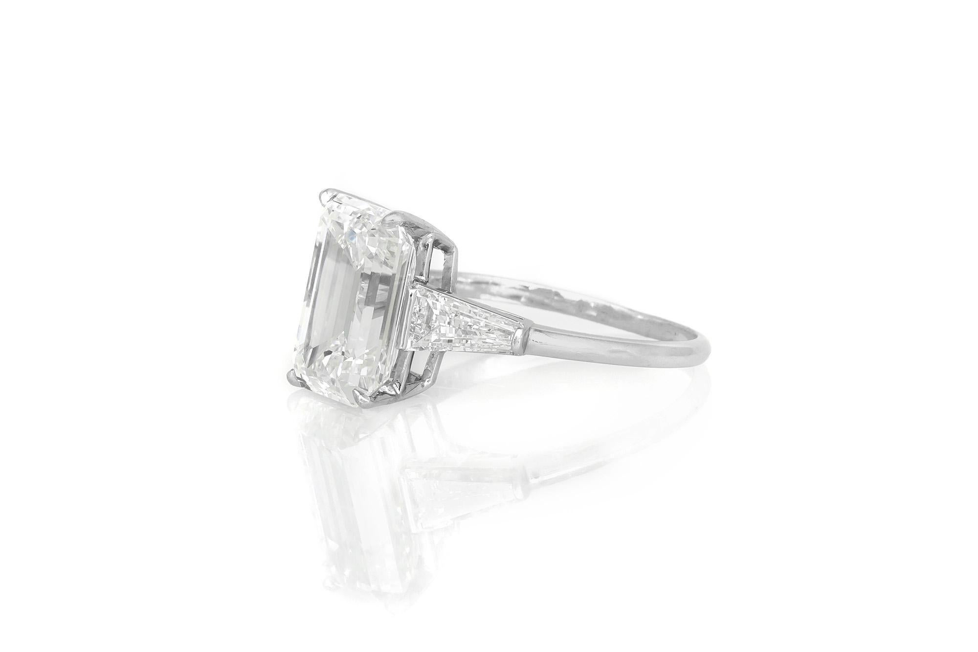 Finely crafted in platinum with a GIA certified Emerald cut Diamond weighing 5.31 carats, G color, VVS2 clarity, GIA #12853547.
The ring features two Tapered Baguette cut Diamonds on the setting.
Size 7 3/4, resizable