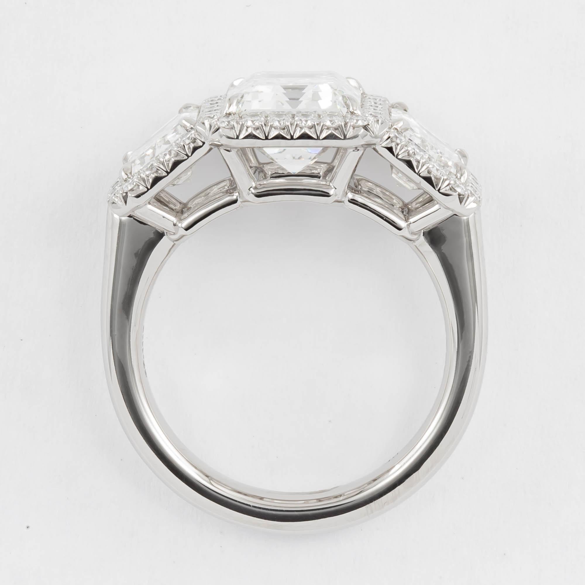 Platinum three Stone Emerald cut diamond Pave diamond ring. This ring features an emerald cut diamond, measuring 9.52x7.28x5.05 mm with a weight of 3.23 carat, G color, SI1 clarity, accompanied by GIA certificate #6187347011. flanked by a pair of