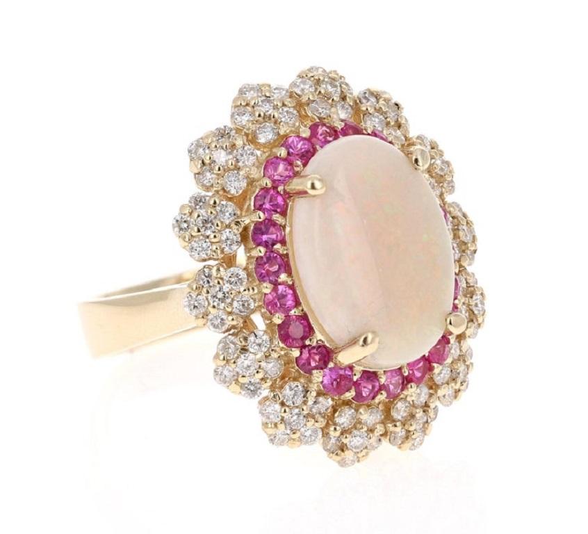 Opal Pink Sapphire and Diamond Yellow Gold Cocktail Ring

This stunning piece has a 3.54 carat opulent Opal set in the center of the ring.  The Opal is surrounded by a row of  22 Pink Sapphires that weigh 0.80 carats and 84 Round Cut Diamonds that