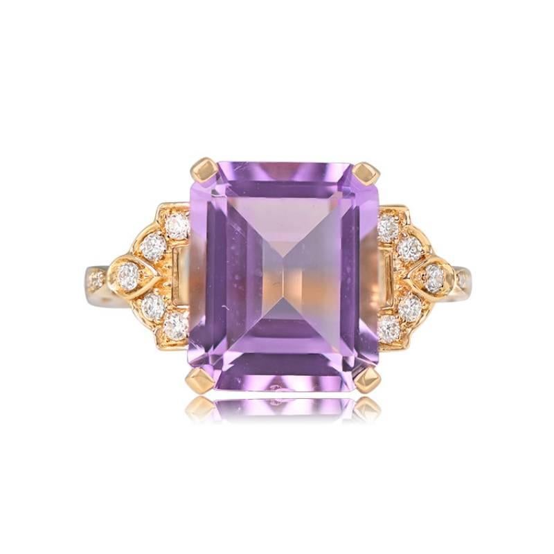 An opulent 18k yellow gold ring featuring a central emerald-cut 5.33-carat amethyst, securely set in prongs. Adorning both sides of the amethyst is a mesmerizing geometric design, accentuated with round brilliant cut diamonds. Additional round