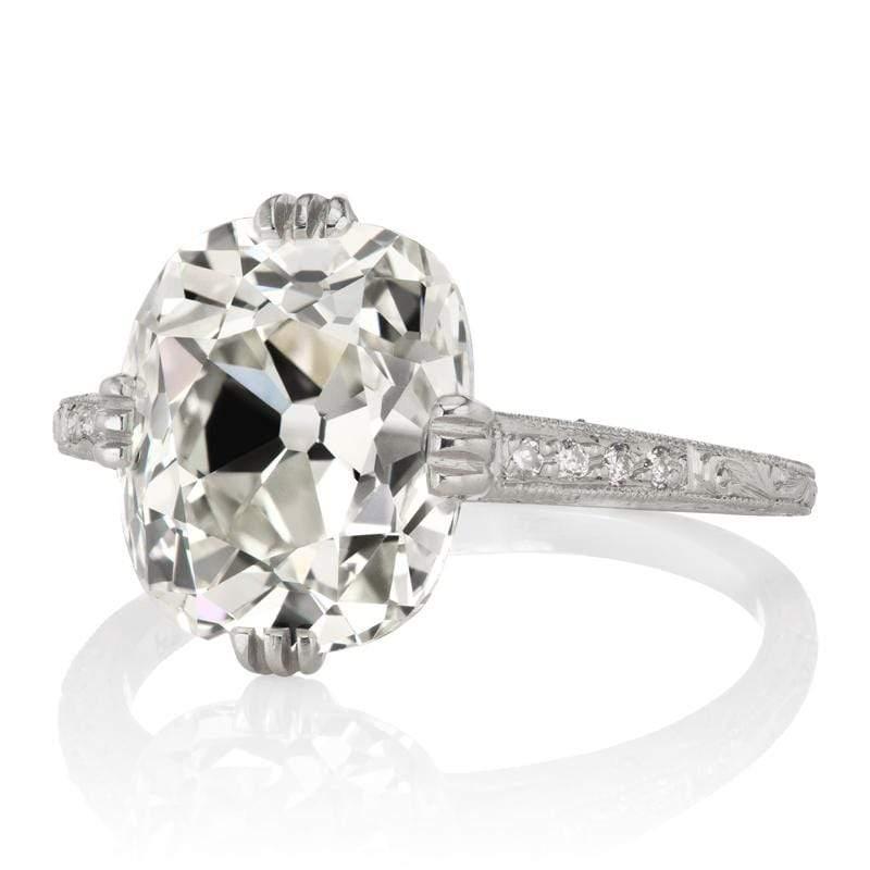 This ring is a VB original made right here in NYC, centering an authentic antique diamond. The ring centers a GIA certified 5.34-carat old mine cut diamond of K color, SI1 clarity. The stone is set in a 4-triple-prong platinum setting with 4 old