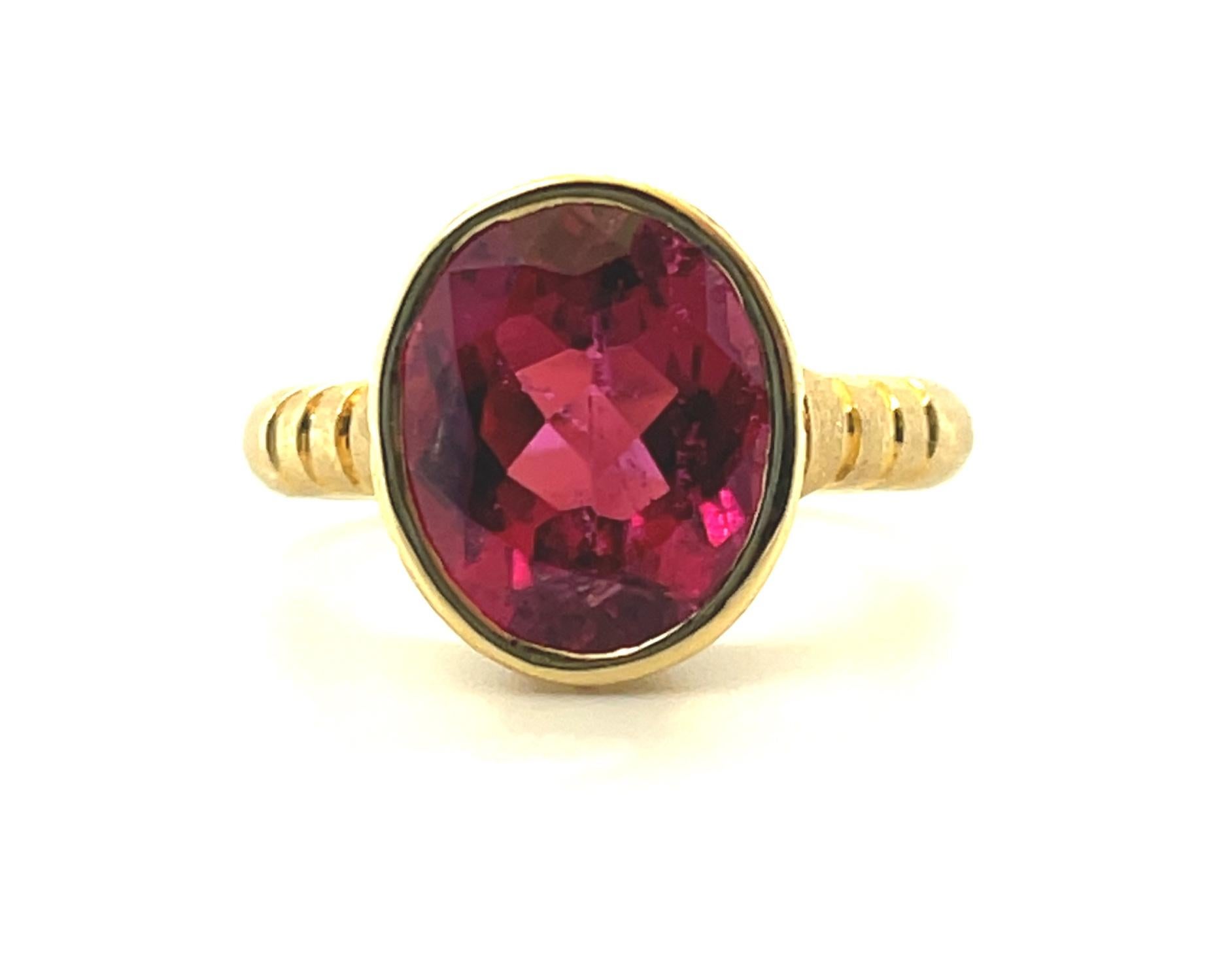 This 18k yellow gold, handmade signature ring features an absolutely stunning rubellite tourmaline of exceptional clarity and vivid, intense pinkish red color. Bezel set with brilliant cut white diamonds, this gem-quality tourmaline shines in a