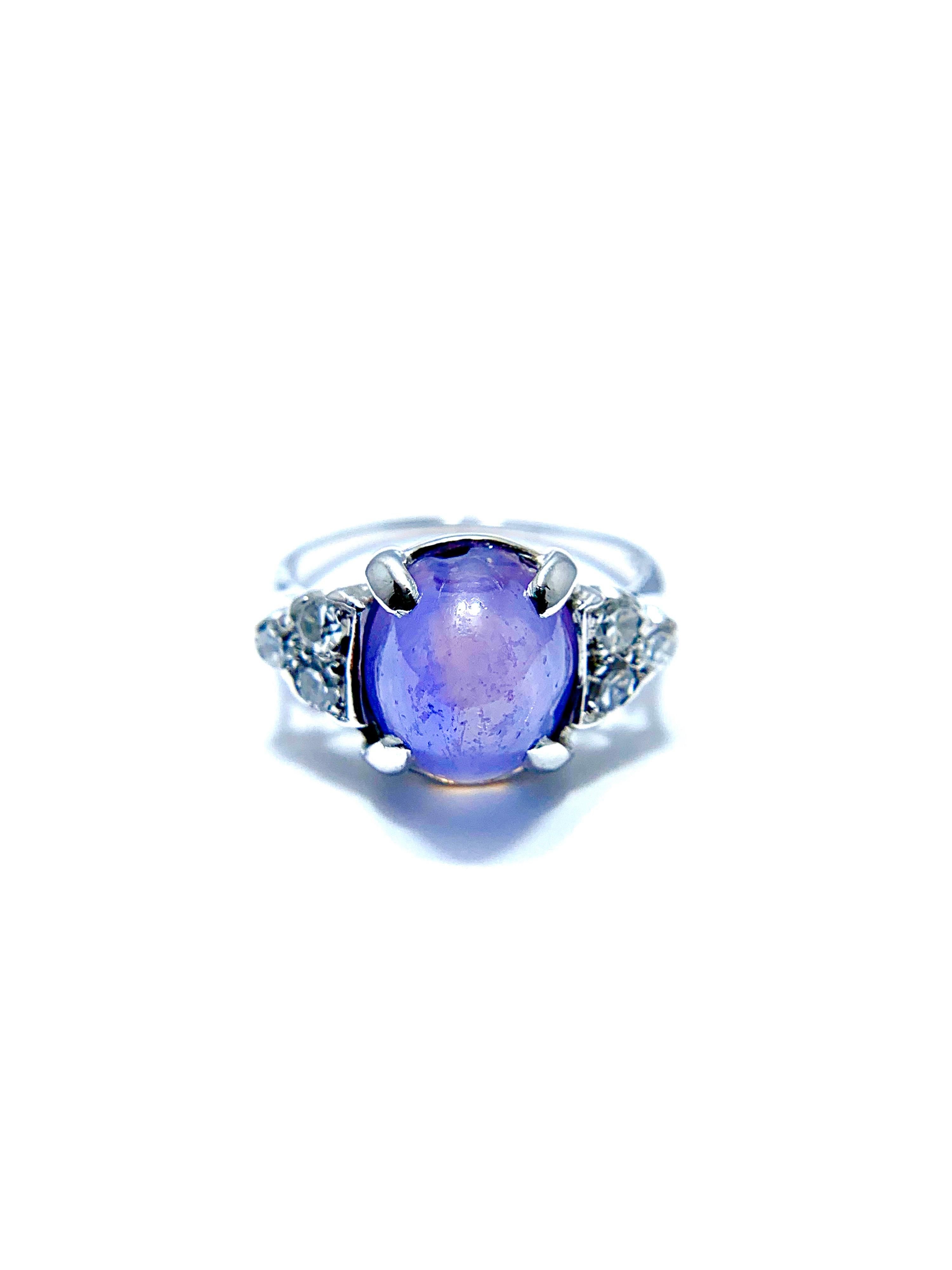 A gorgeous lavander cabochon Sappjhire and Diamond cocktail ring set in 14k white gold!  The 5.36 carat cabochon Sapphire is set in four prongs with three single cut round brilliant Diamonds on each side totaling 0.10 carats.  The shank is stamped