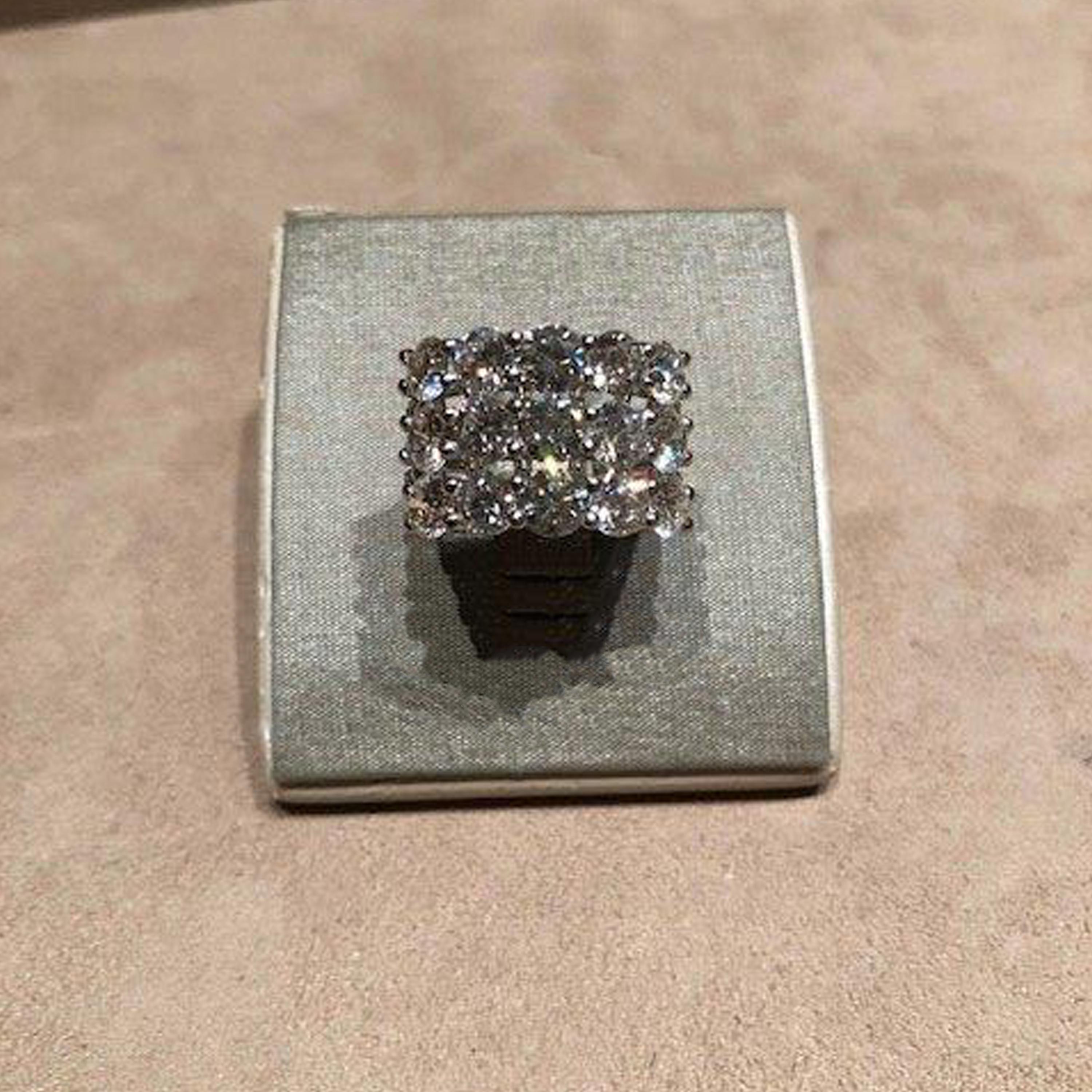 This platinum three row ring showcases 15 round brilliant cut diamonds weighing
4.93 carats total. H-I color, VS-SI clarity. There are 42 full cut diamonds on the sides of the shank that weigh .41 carats total. The width of the ring is 13.5 mm and