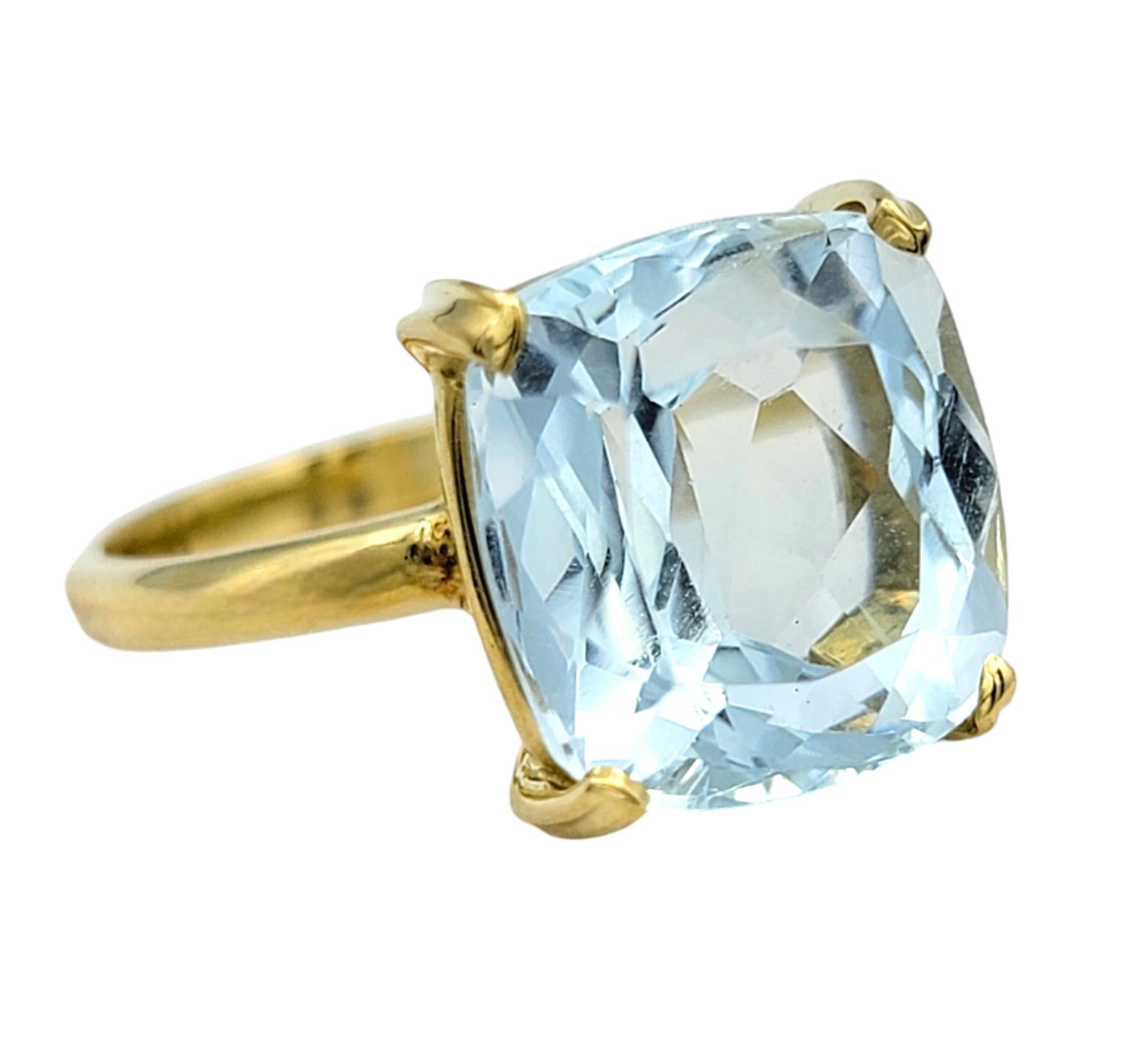 Ring Size: 6 

Embrace the serene beauty of the ocean with this stunning 5.38 carat cushion-cut aquamarine solitaire ring, a true masterpiece of elegance. Set in luxurious 18 karat yellow gold, the vibrant aquamarine gemstone dazzles with its