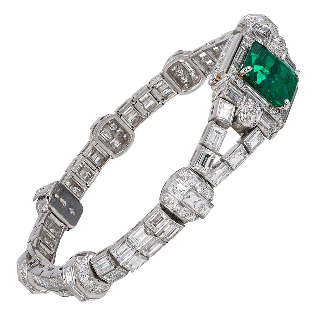 This important mid-20th century platinum bracelet has been artfully appointed with 12.50 carats of baguette and round brilliant cut white diamonds, however the most noteworthy component is the show-stopping emerald centerpiece. The gemstone weighs