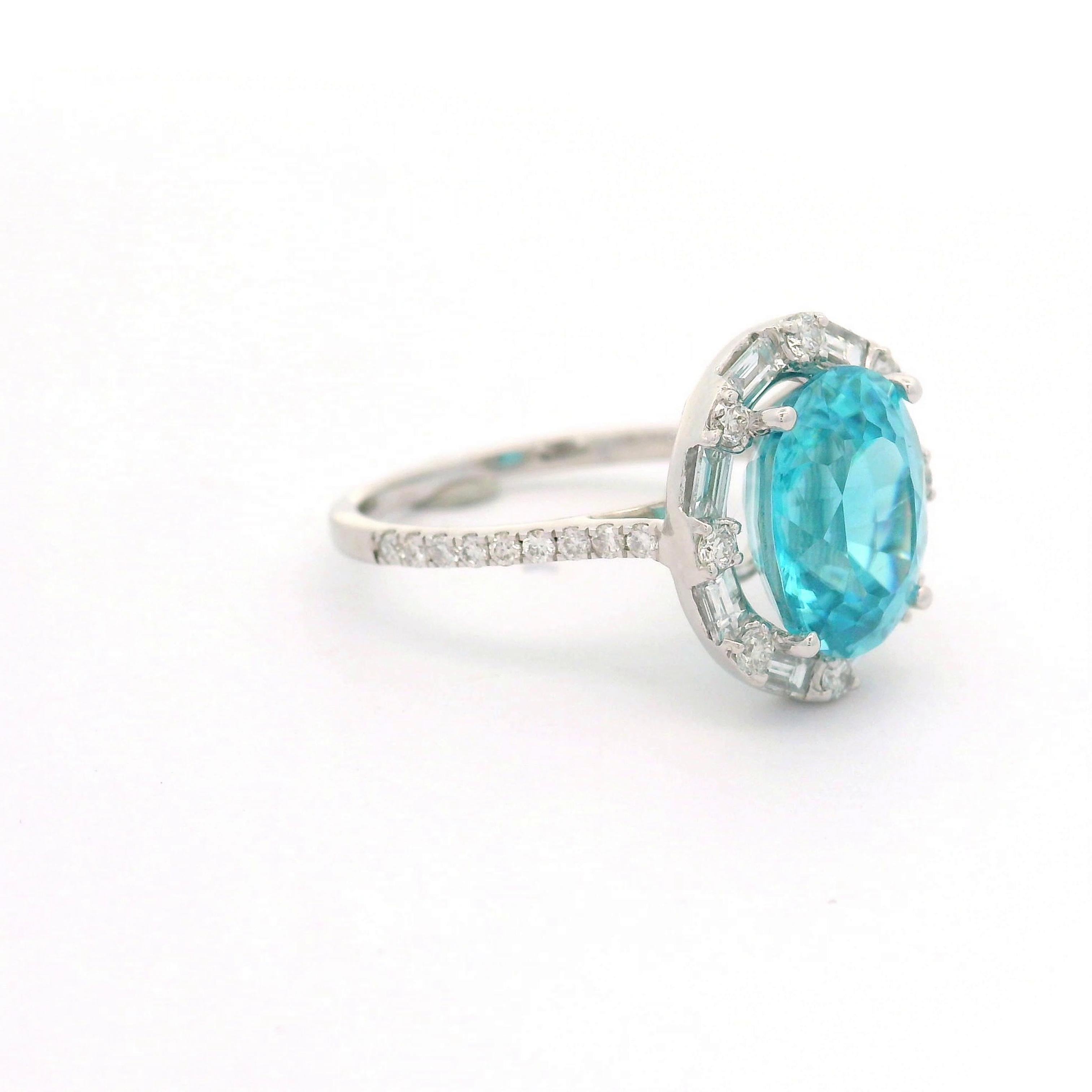 An exquisite blue zircon, weighing 5.39 carats, is the centerpiece of this contemporary ring. The zircon, cut in an elegant oval shape, radiates a vibrant blue hue. Surrounding the central stone are mixed-cut diamonds, totaling 0.68 carats, which