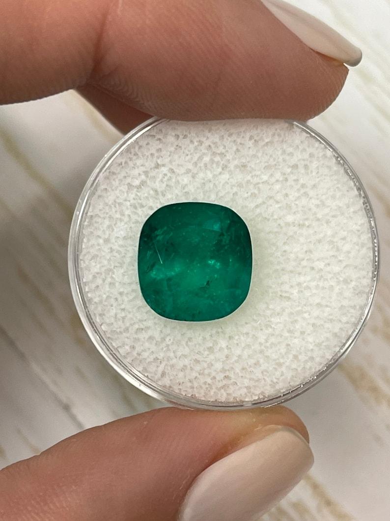 Stone: Emerald
Weight: 5.39-carats
Shape: Cushion Cut
Clarity: Transparent
Luster: Very Good
Color: Dark Muzo Green
Measurements: 10.84mm x 10.45mm x 8.04mm
Geographic Origin: Colombia
Treatment: Natural, Oiling

Comments: Due to their growth