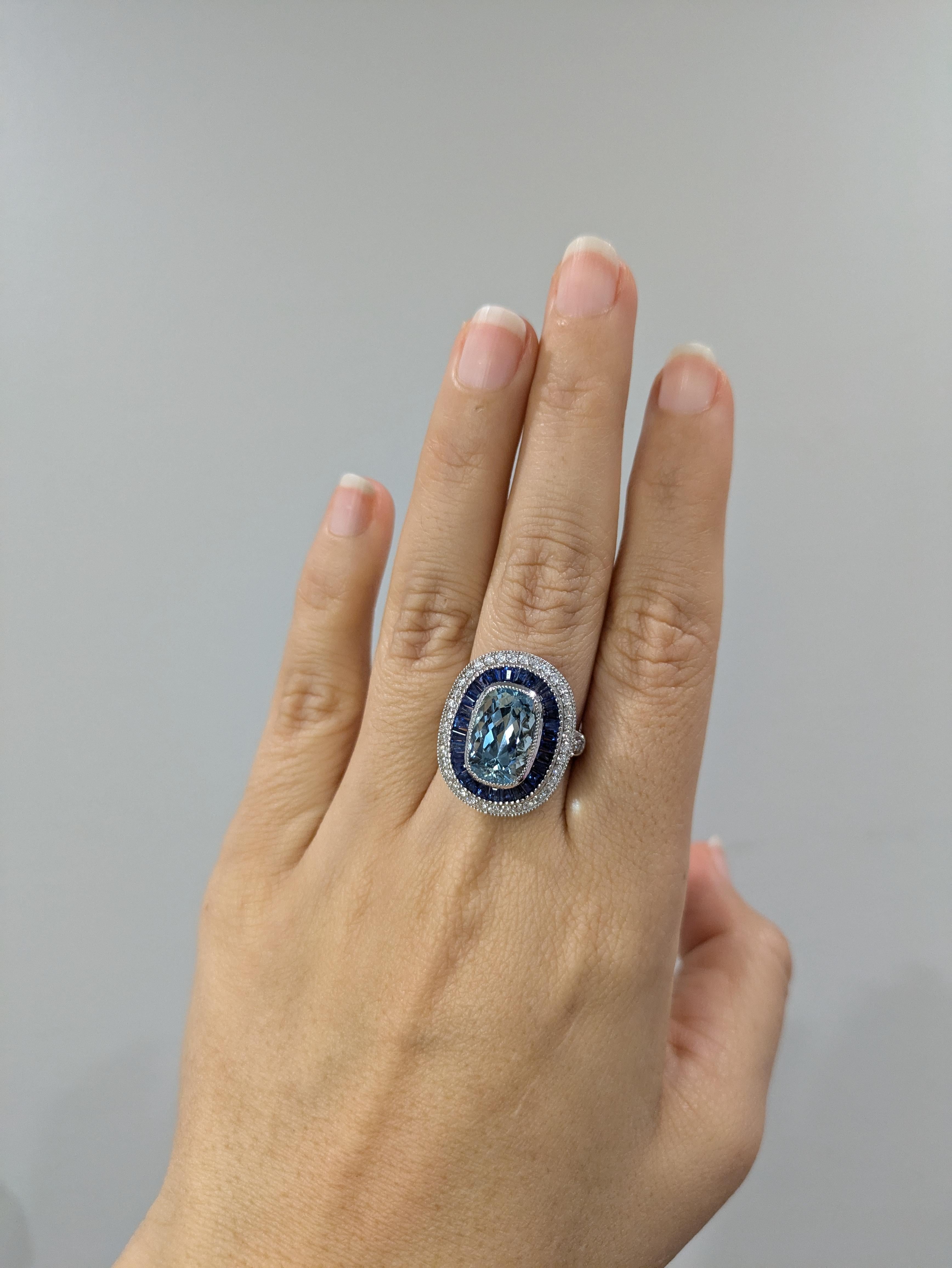 This exquisite ring is a stunning addition to any jewelry collection. Featuring a captivating 5.3 carat Aquamarine as its center, it is surrounded by a halo of natural earth mined diamonds and blue sapphire halo set in solid 14K white gold. This