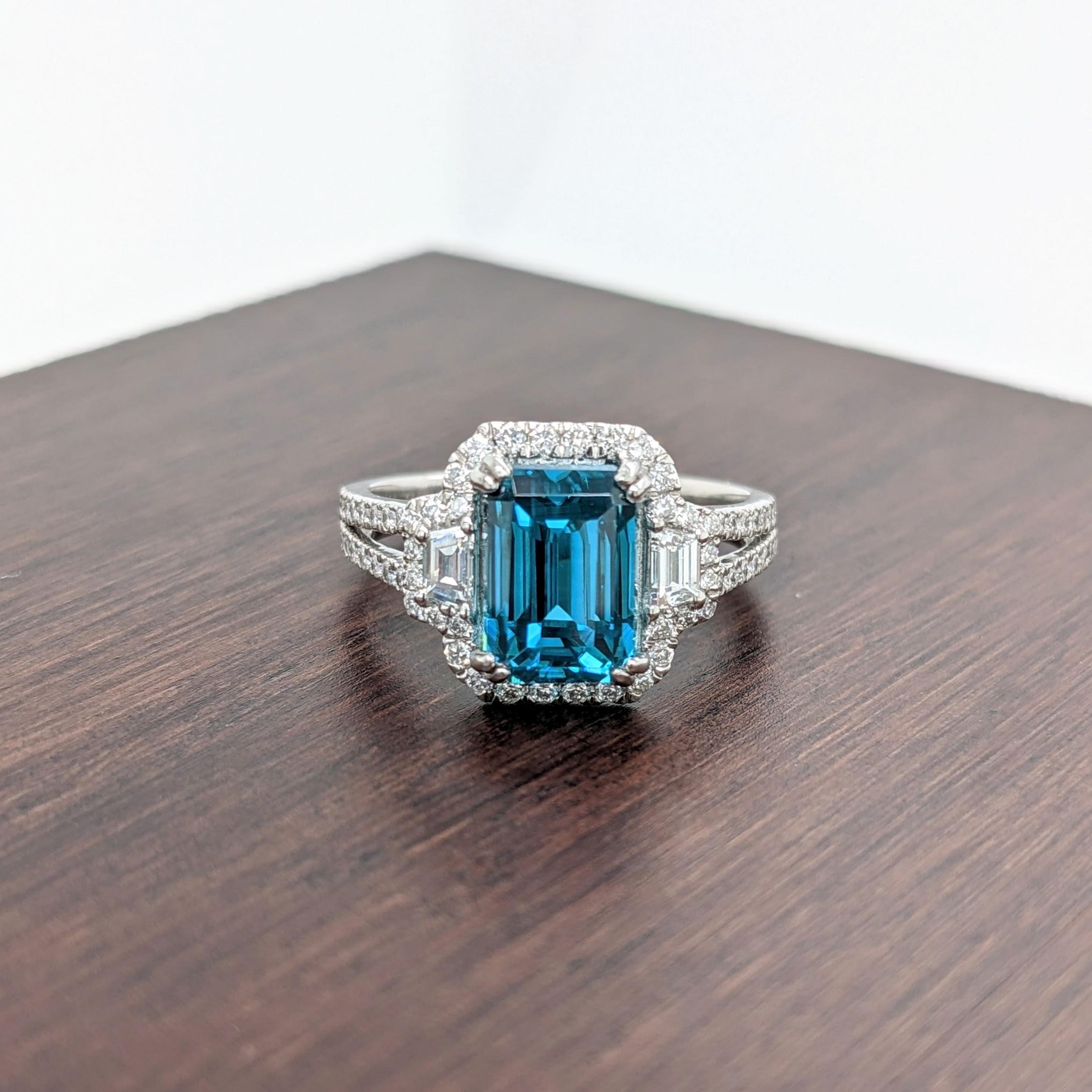 Claim this captivating natural blue zircon for yourself or your loved ones! A masterpiece of nature set in one of our most popular NNJ ring designs made in Platinum with a diamond halo and diamond studded split shank. A gorgeous ring for a modern