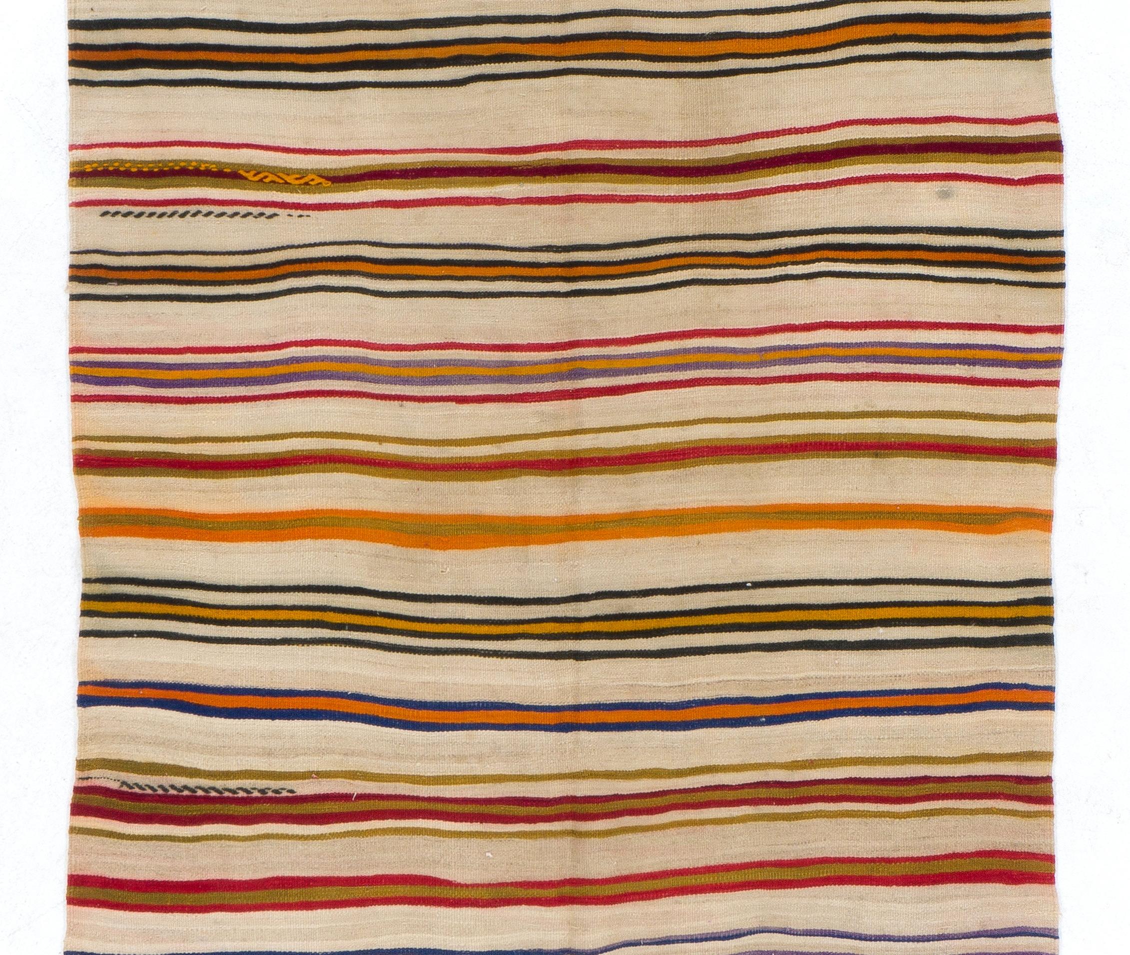 A kilim/flat-weave made of wool handwoven by the nomadic tribes in the 1960s in South Central Turkey with a minimalistic striped design in a gorgeous, bright and warm color palette of deep saturated orange, red, burgundy, royal blue, chartreuse