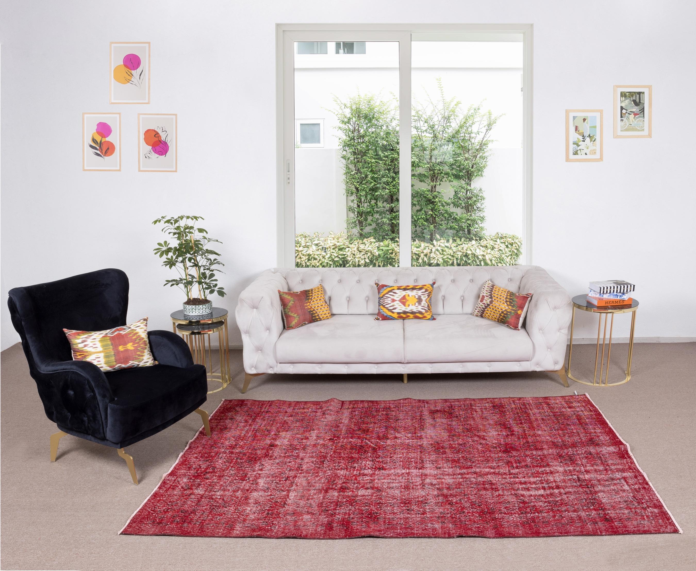 Elevate your space with the bold and captivating presence of a Handmade Turkish Area Rug Overdyed in Red. This exquisite rug embodies the rich heritage of Turkish craftsmanship, combining traditional techniques with contemporary flair to create a