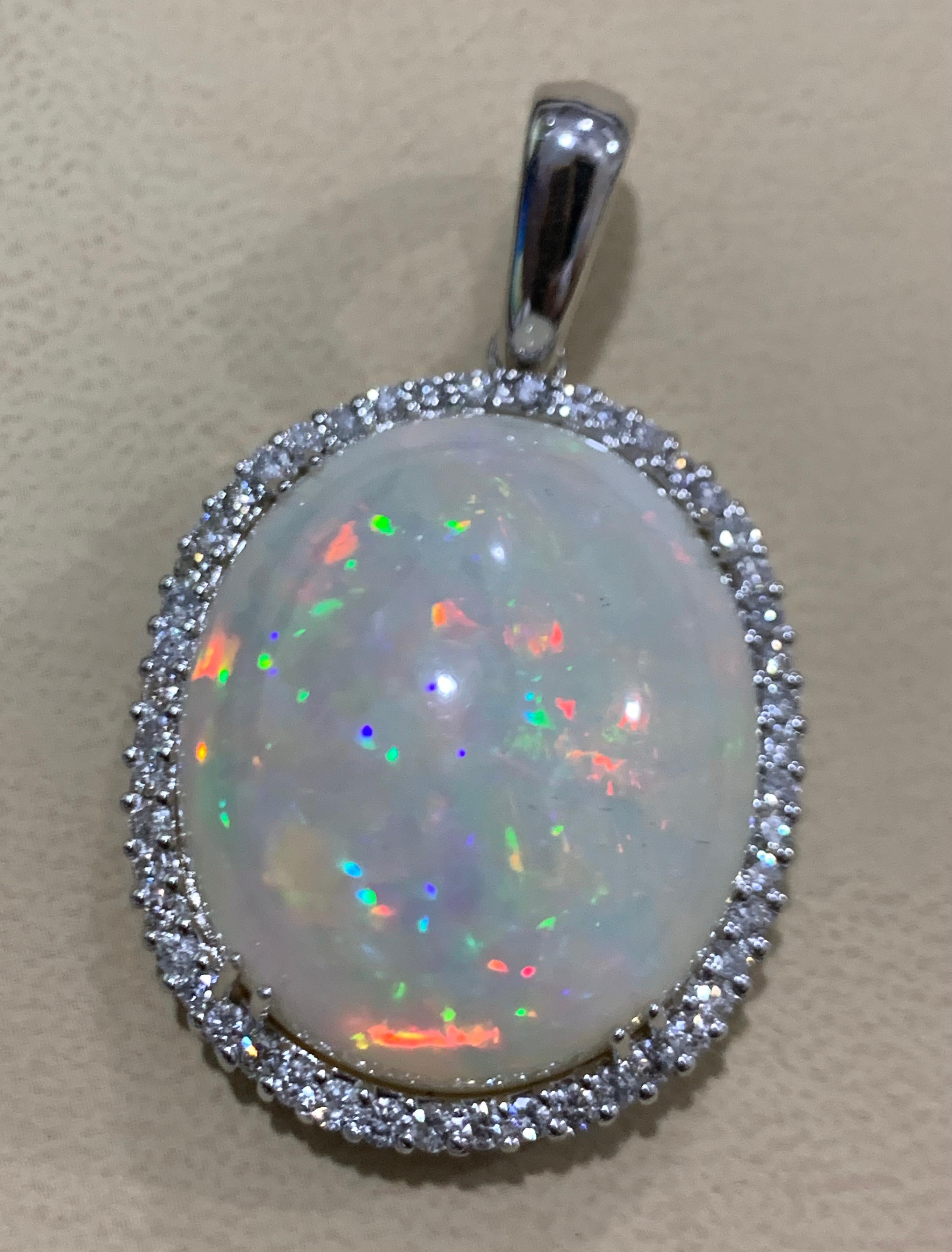 54 Carat Oval Ethiopian Opal & Diamond Pendant / Necklace 14 Karat Gold Estate White Gold 
This spectacular Pendant Necklace consisting of a single Oval Shape Ethiopian Opal Approximately 54 Carat. The Opal is surrounded by approximately 2.2 Carats