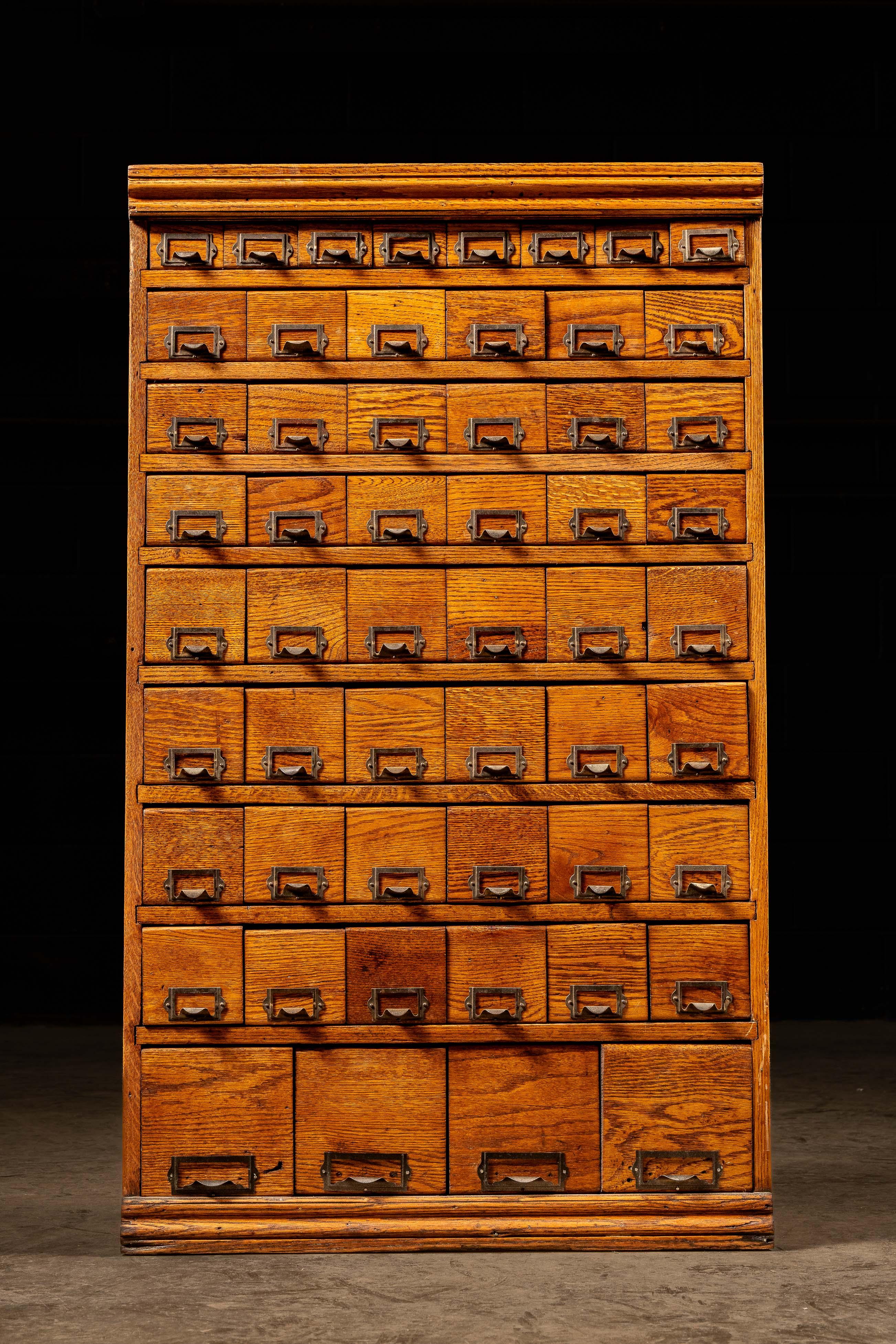 An antique oak multi-drawer cabinet, likely from the 1920s.

This piece features striking wood grain that is further enhanced by the rich, brown stain and varnish. Includes a multitude of drawers in four different sizes that each include brass
