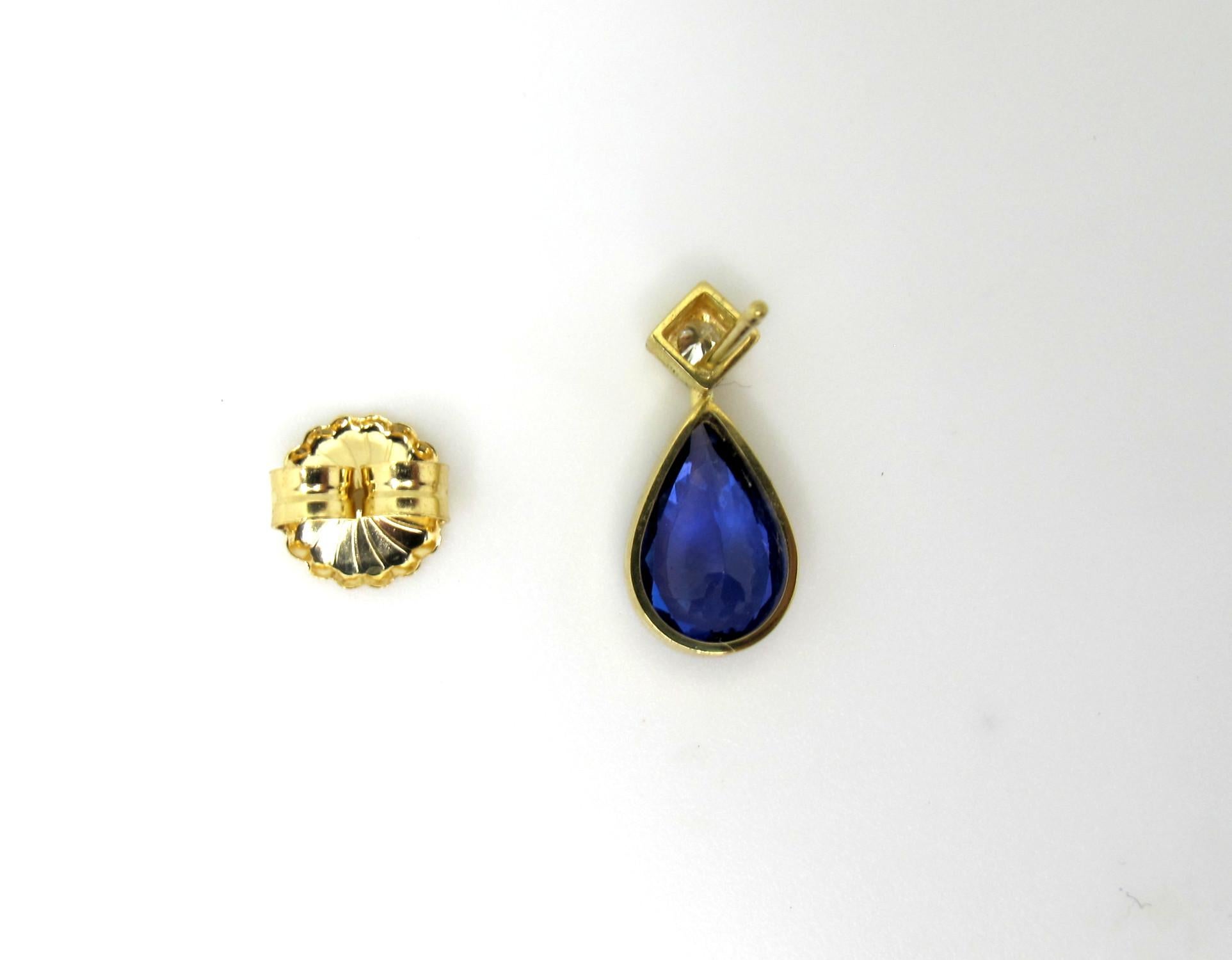 These show-stopping drop earrings feature rich, lavender blue tanzanite pears that have been bezel set in 18k yellow gold and topped with a sparkling diamond! The tanzanites are beautifully matched, breathtaking in color, and extremely