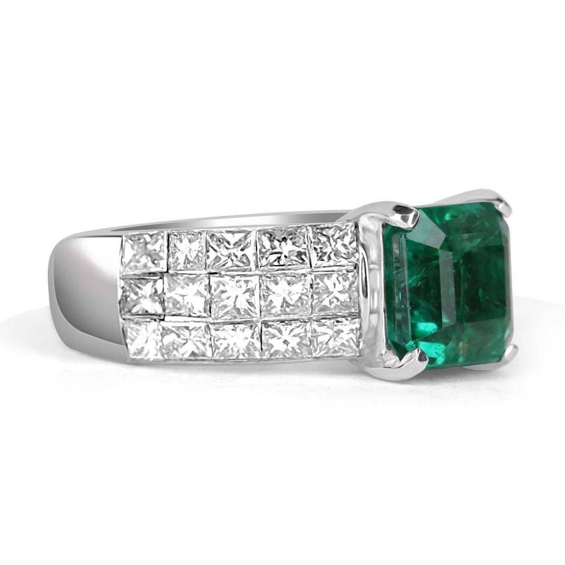 Bold and unique, this 18K gold ring says it all. The men's emerald & invisible set diamond ring features an excellent design. Dextrously set, the emerald sits within its custom-built basket. The earth-mined gem shows a vivacious green color that
