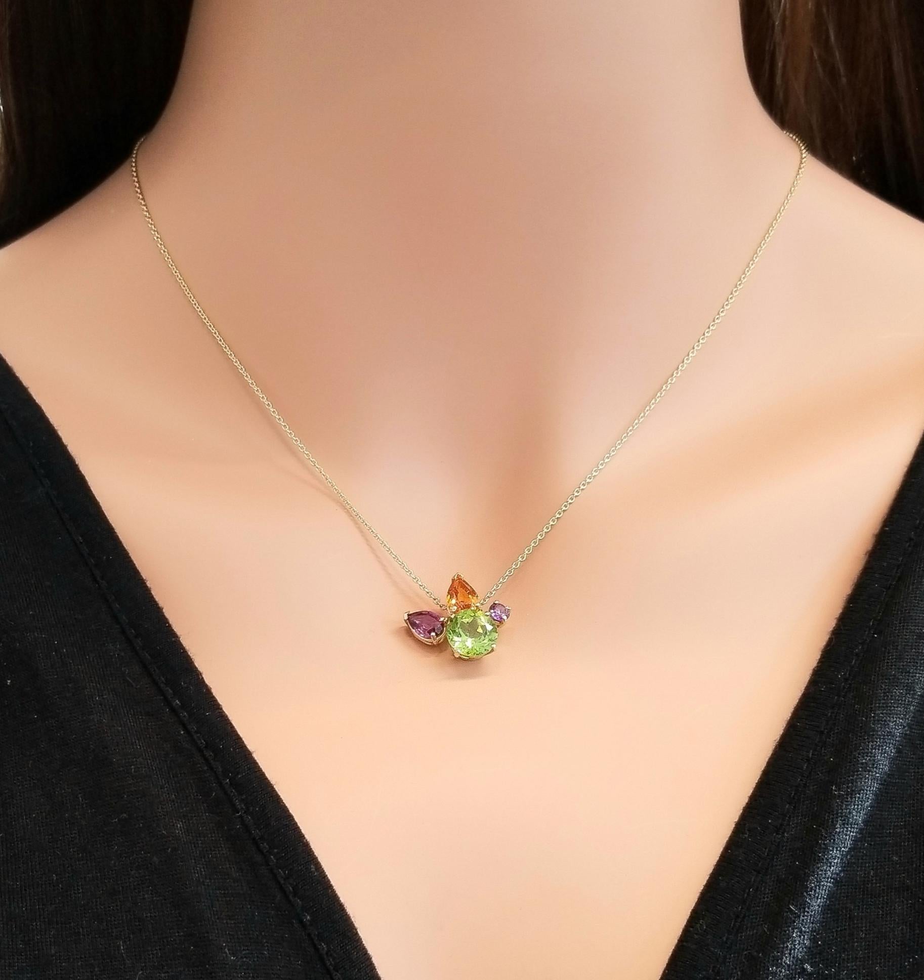  This rainbow gem cluster necklace is the ultimate arrangement of color play. 5.41 carats of semi-precious colored gems adorn this vibrant necklace featuring one peridot, one amethyst, citrine, and purple garnet, in a beautiful bouquet. All of the